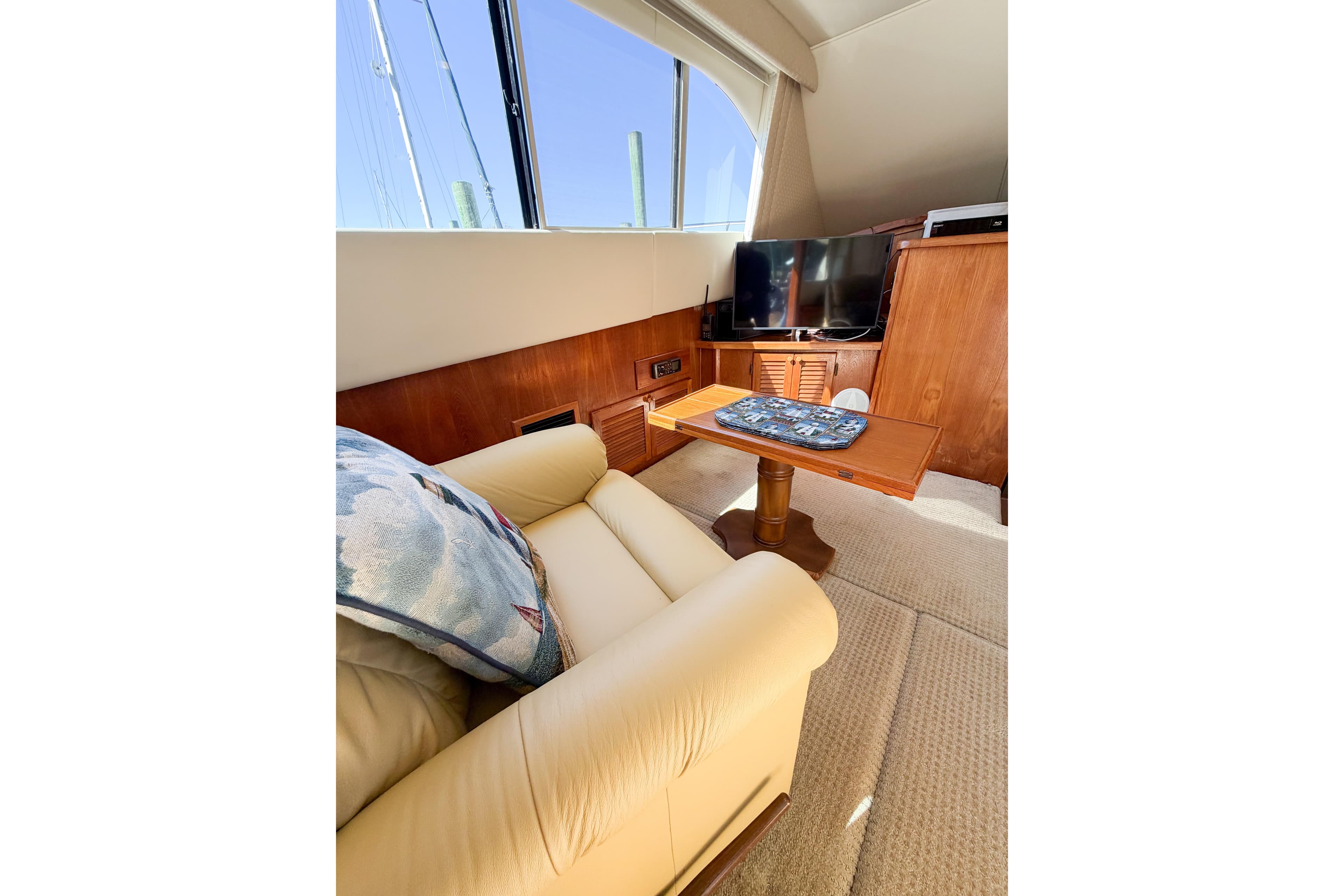 Interior of 1988 Pacemaker 36 Convertible yacht with sofa, table, and TV.