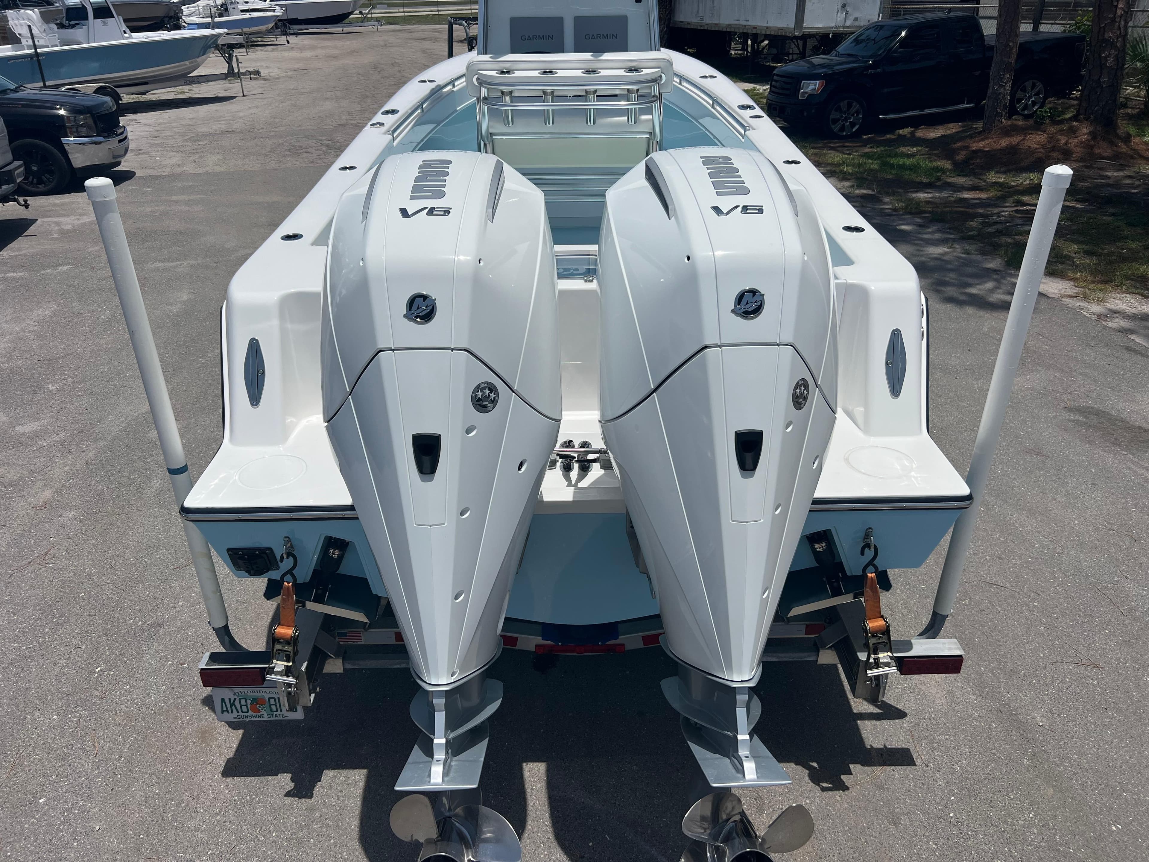 2023 Contender 25 Tournament boat with dual V6 engines, rear view in a parking area.