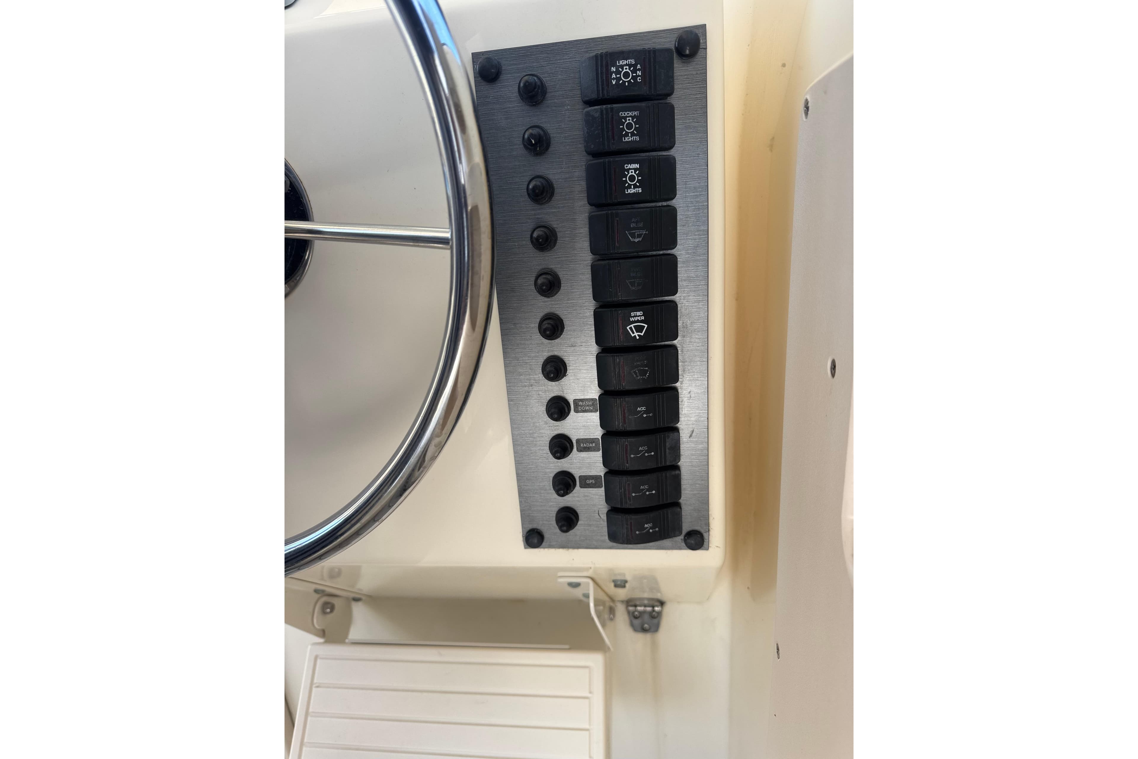 Control panel of a 2002 Parker 2510 Walkaround boat with steering wheel and switches.