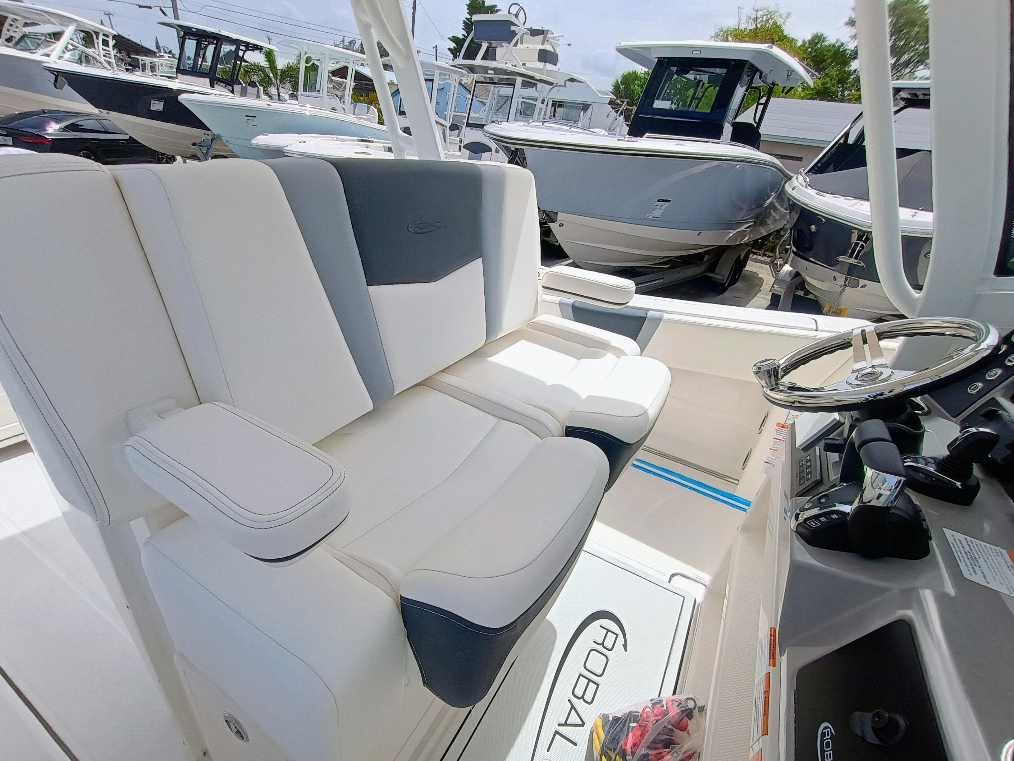 2025 Robalo R270 Center Console boat interior with white and gray seating, steering wheel, and controls.