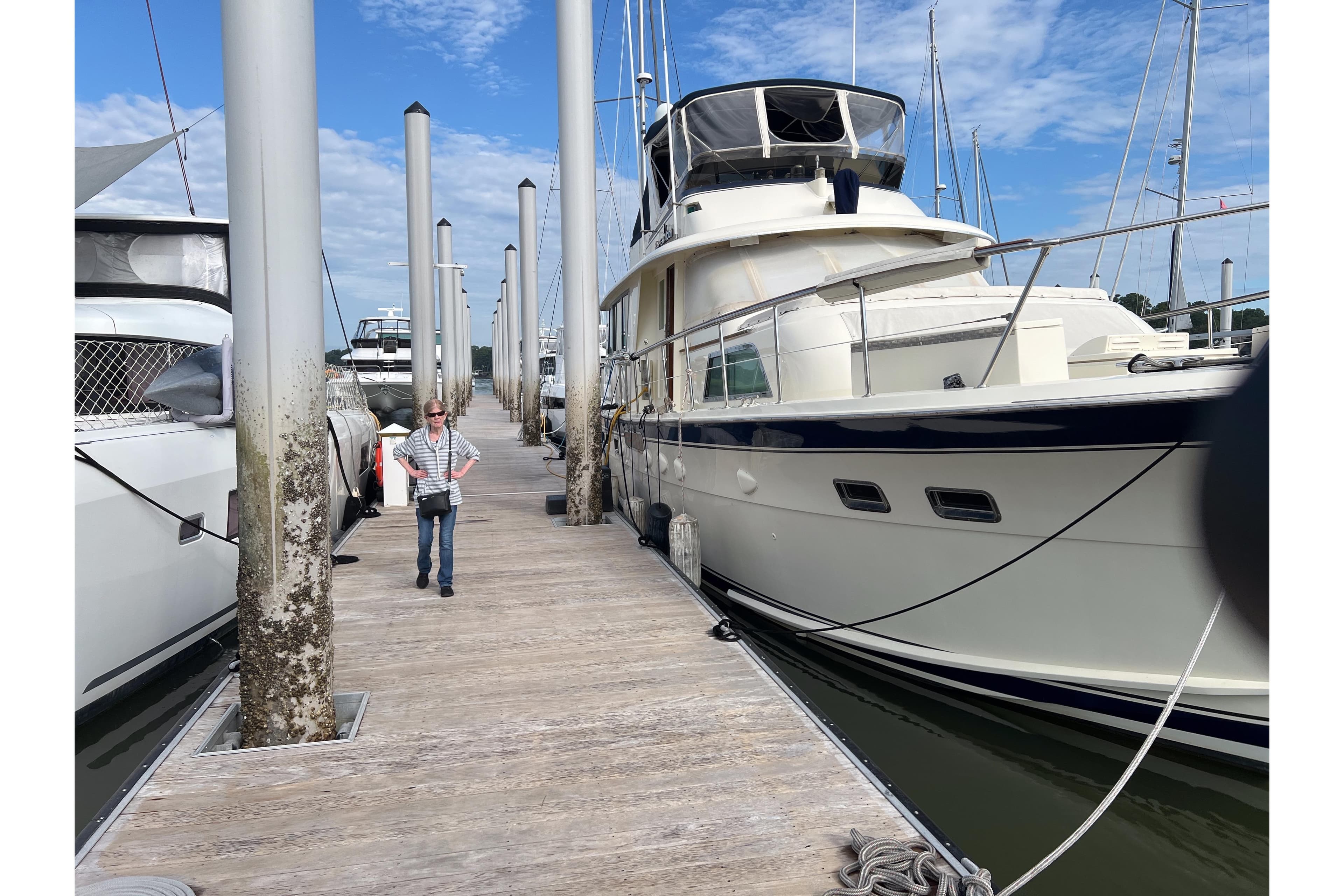 1983 Hatteras 53 Extended Deckhouse Motor Yacht docked at marina under blue sky.