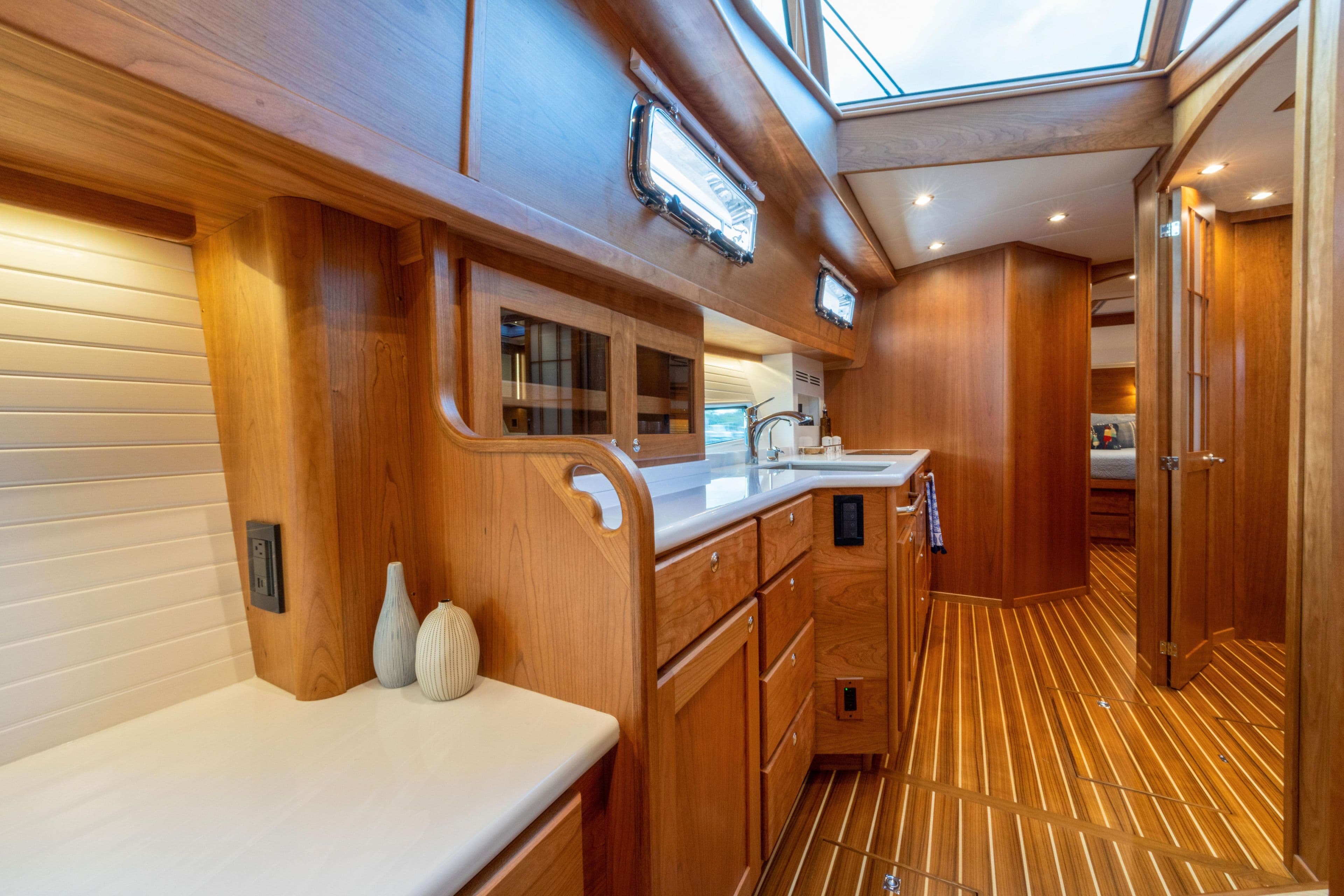 Luxurious interior of 2027 Sabre 51 Salon Express yacht with wooden cabinetry and modern amenities.