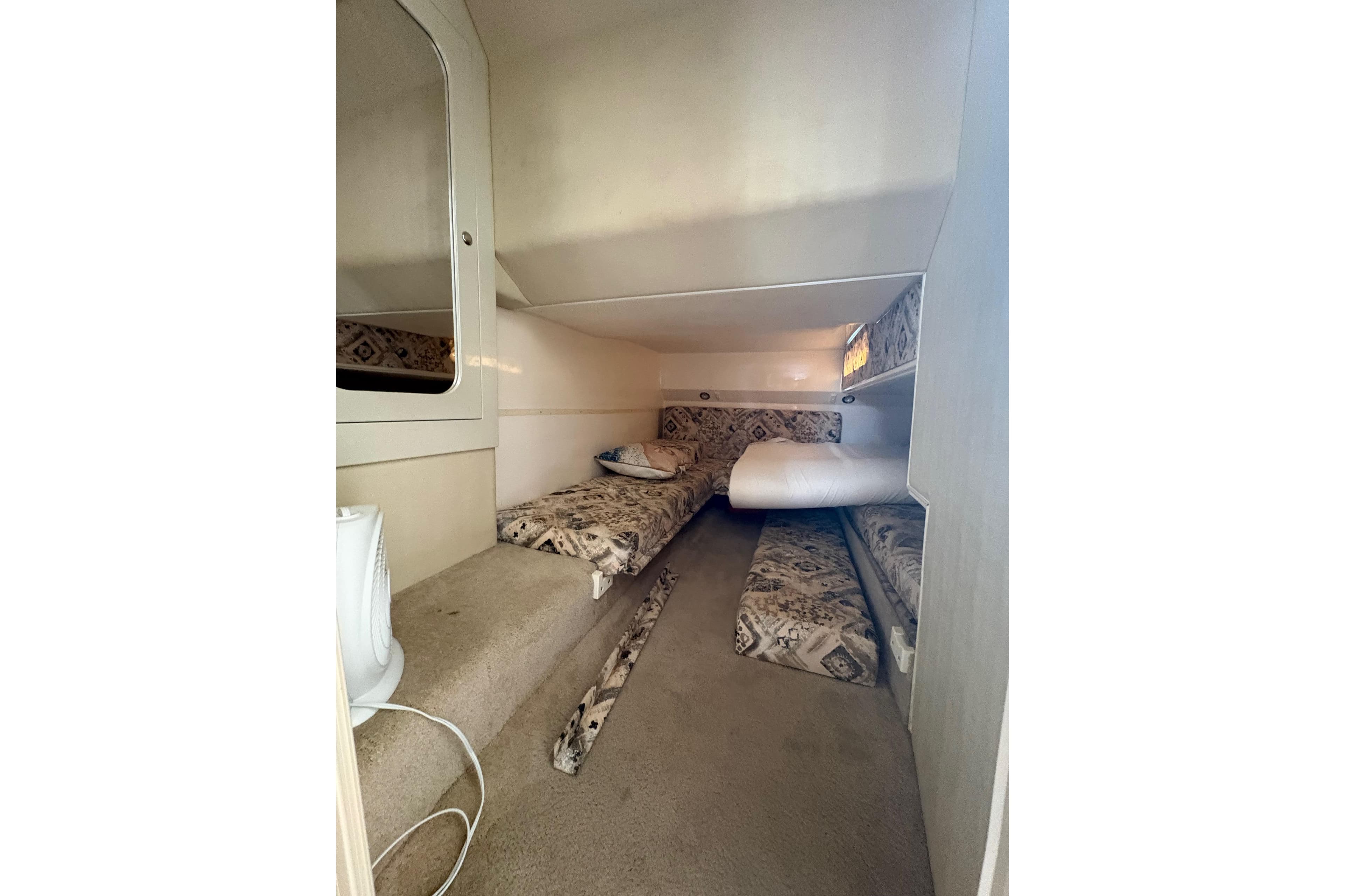 Interior cabin of 1999 Wellcraft 45 Excalibur with patterned cushions and compact design.