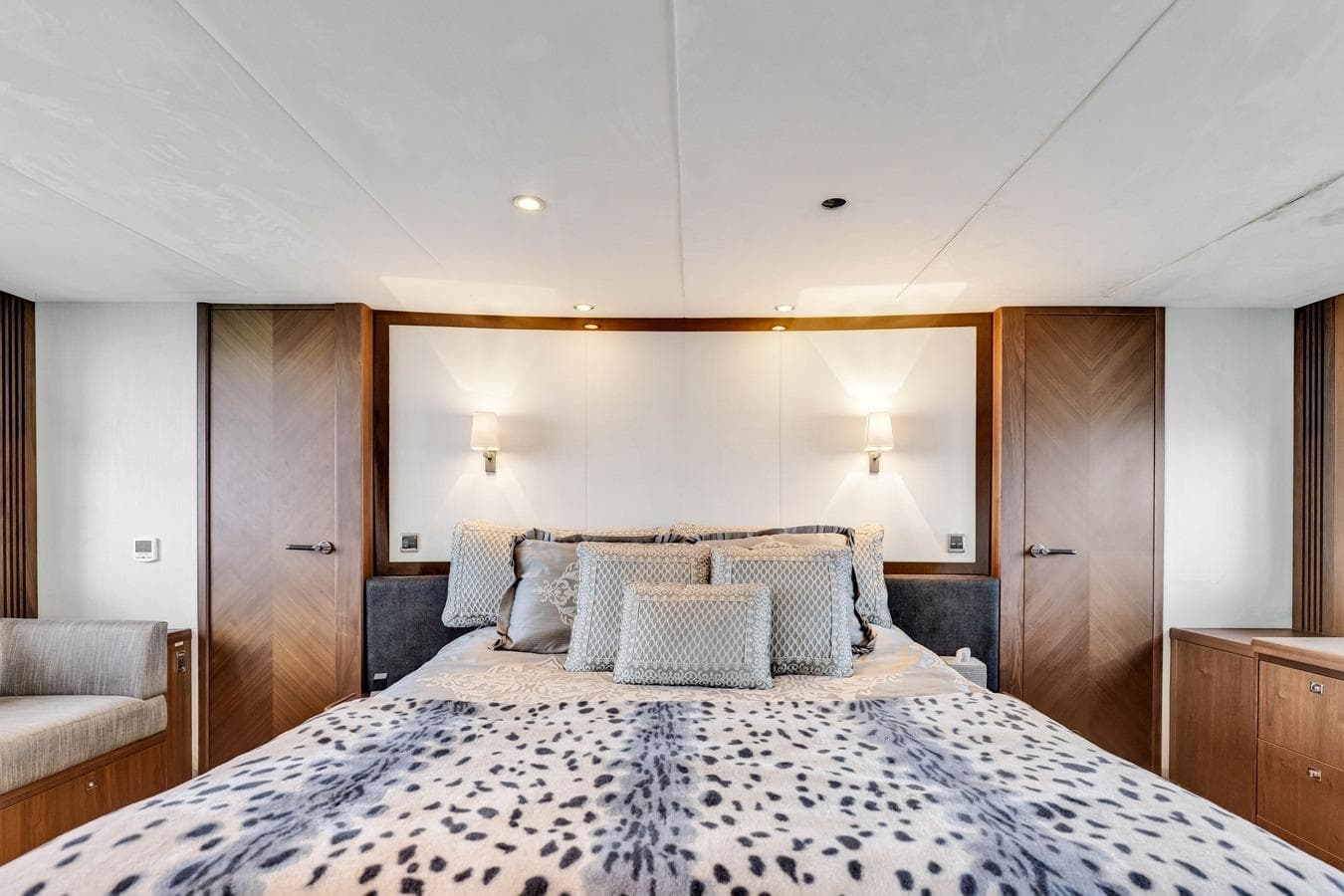 Luxurious bedroom interior on a 2012 Princess 85 yacht, featuring elegant bedding and modern lighting.