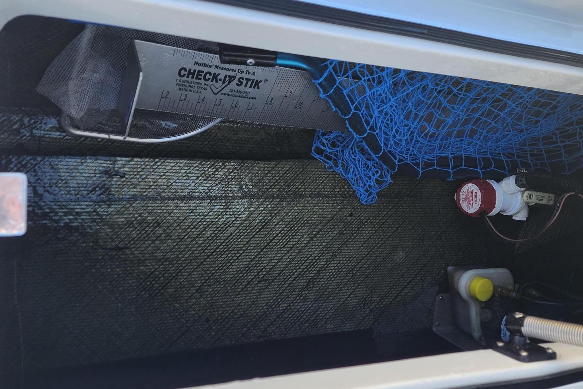 Storage compartment of 2022 East Cape Vantage VHP with fishing gear and equipment.