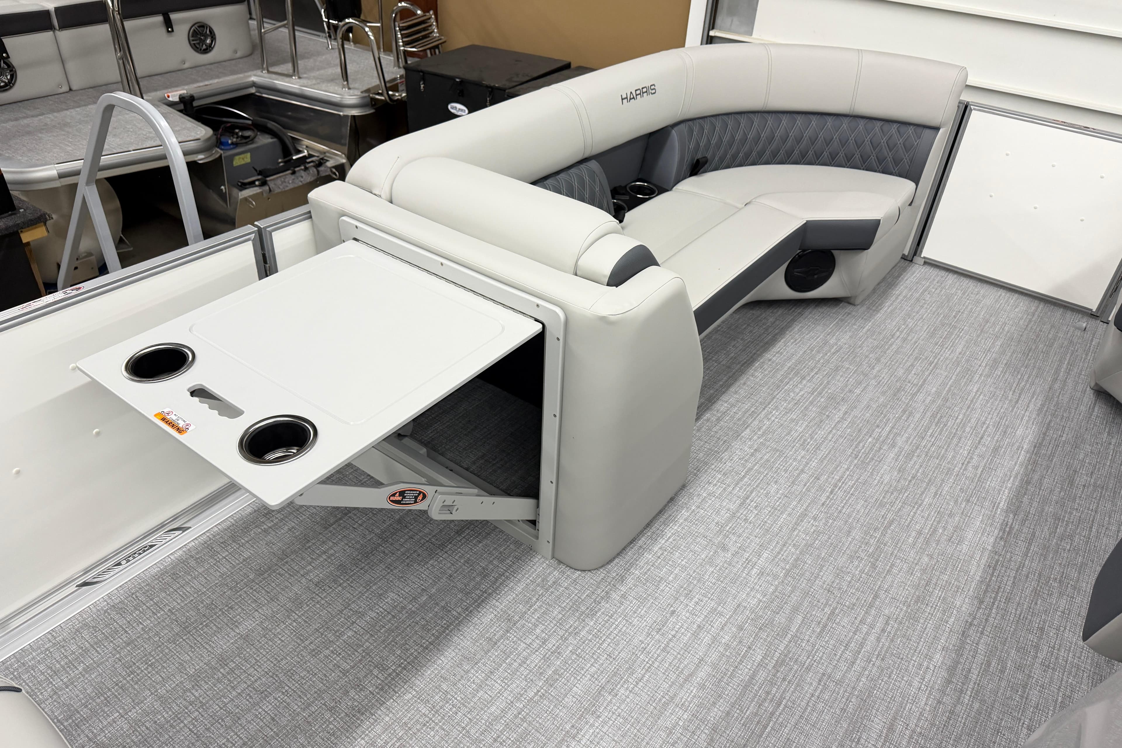 2026 Harris Cruiser 230 interior with gray seating and foldable table.