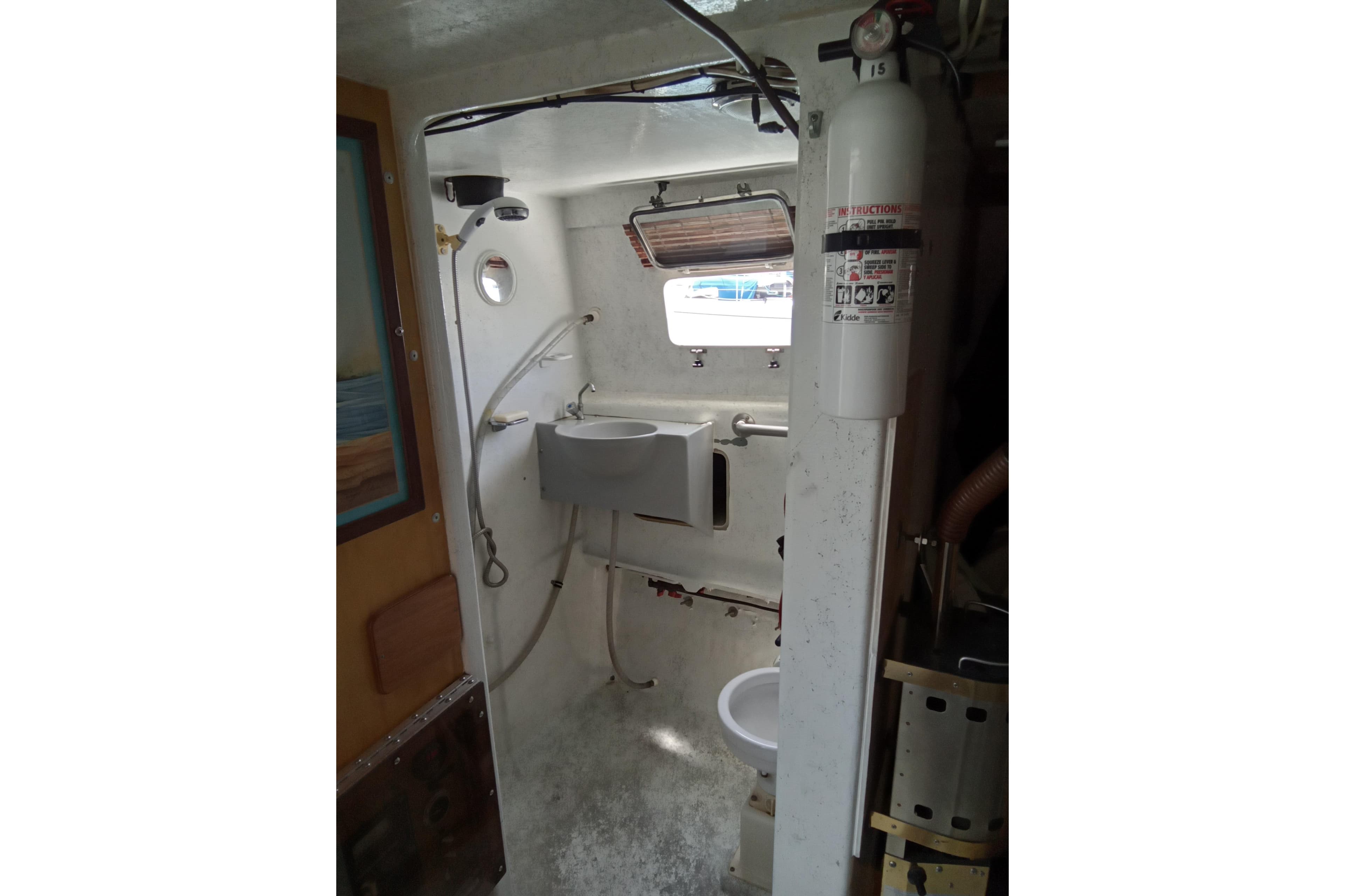 1972 Uniflight 40 boat interior with sink, toilet, and fire extinguisher.