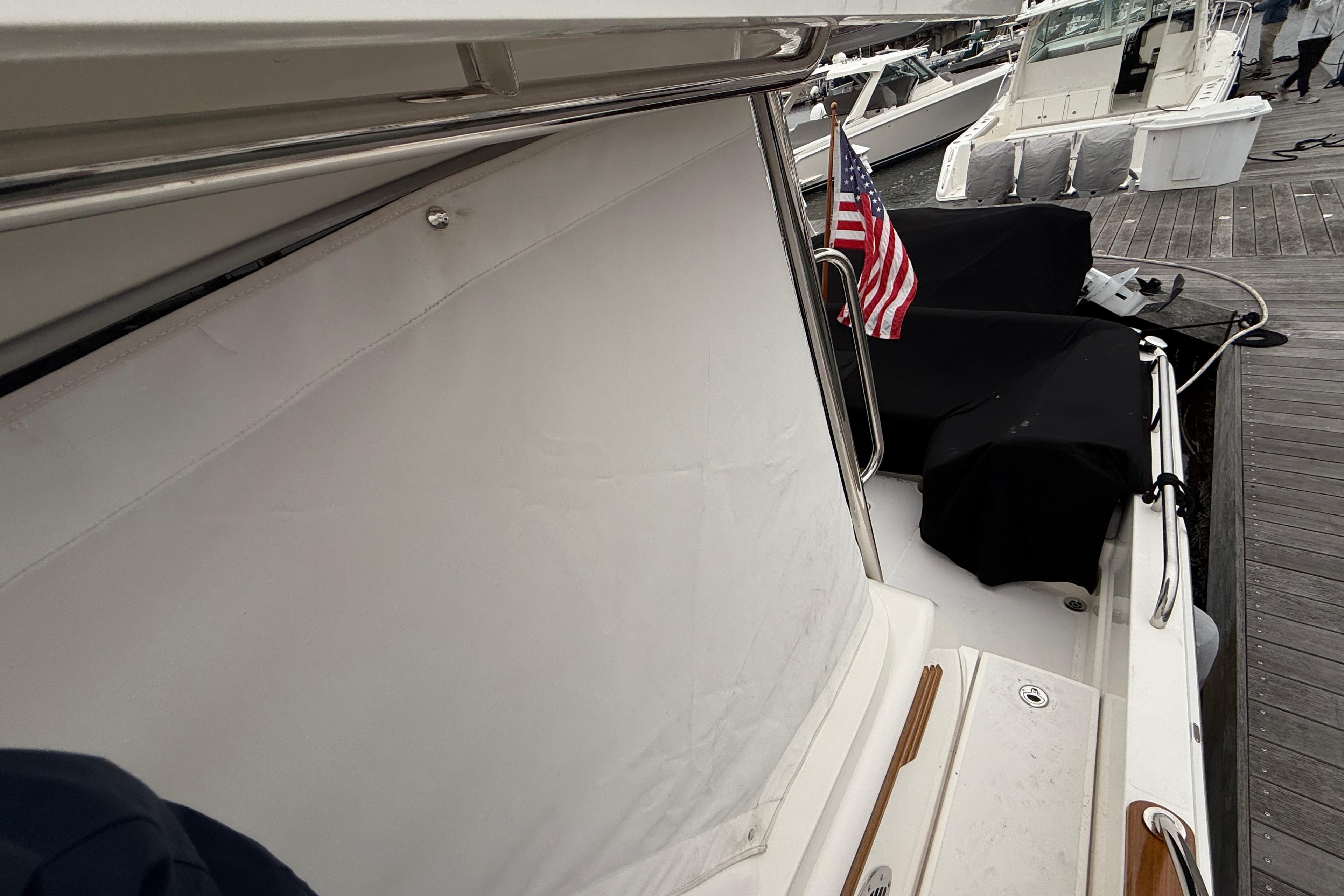 2023 Sabre 43 Salon Express yacht docked, featuring American flag and covered seating area.