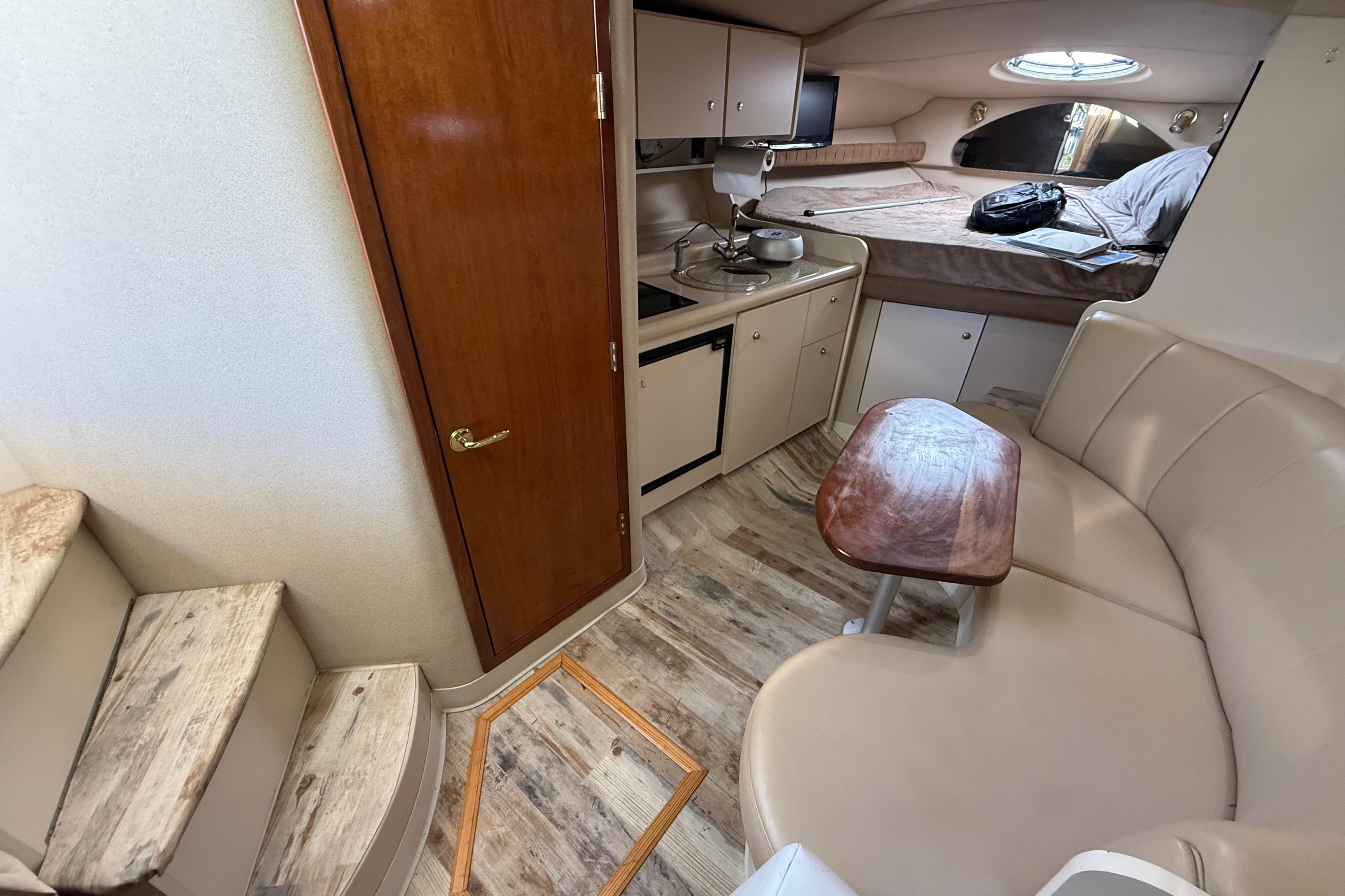 Interior of 2003 Cruisers Yachts 3075 Express, featuring kitchenette, seating, and sleeping area.