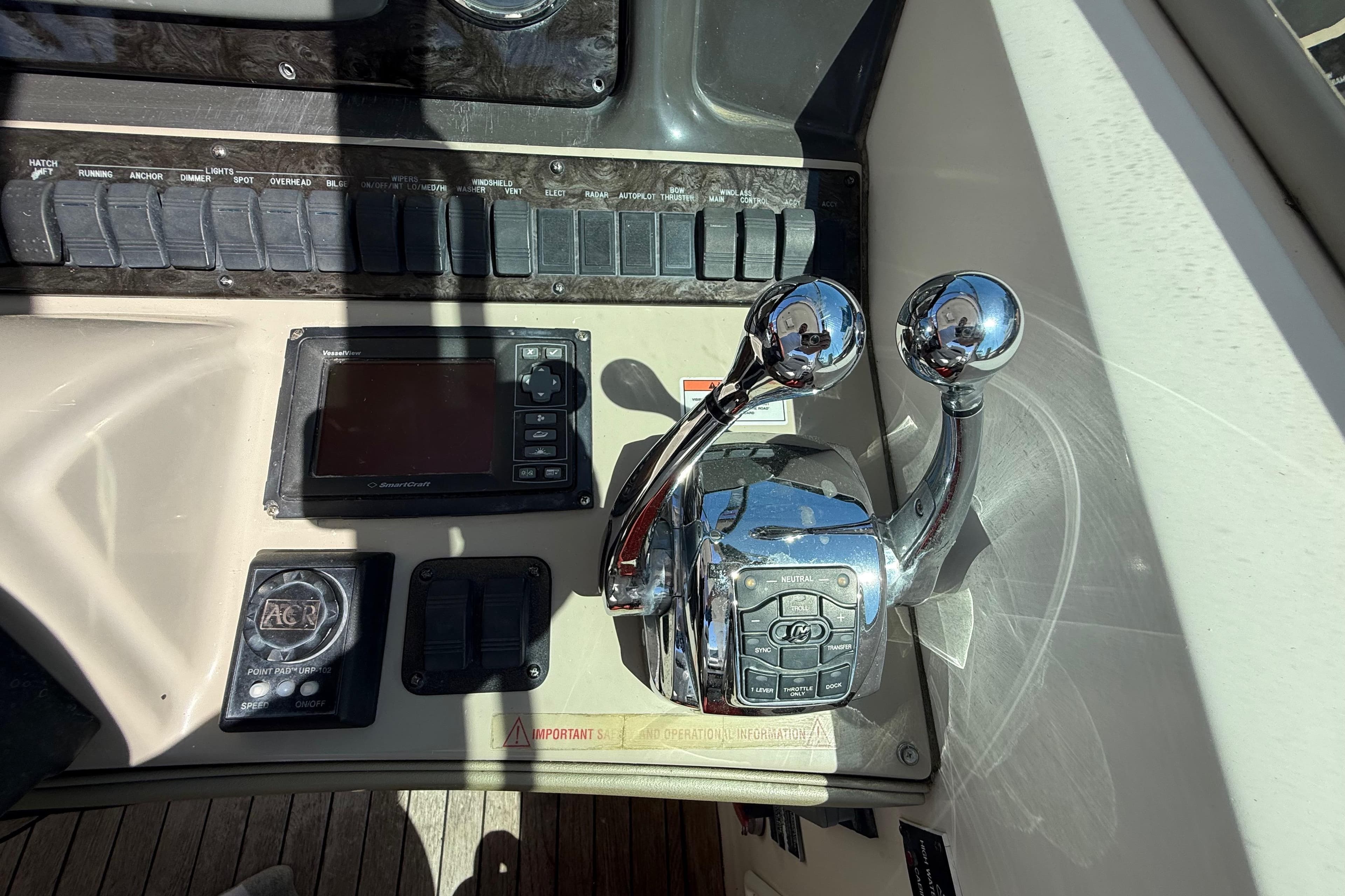 Control panel of a 2008 Sea Ray 38 Sundancer boat with throttle levers and navigation display.