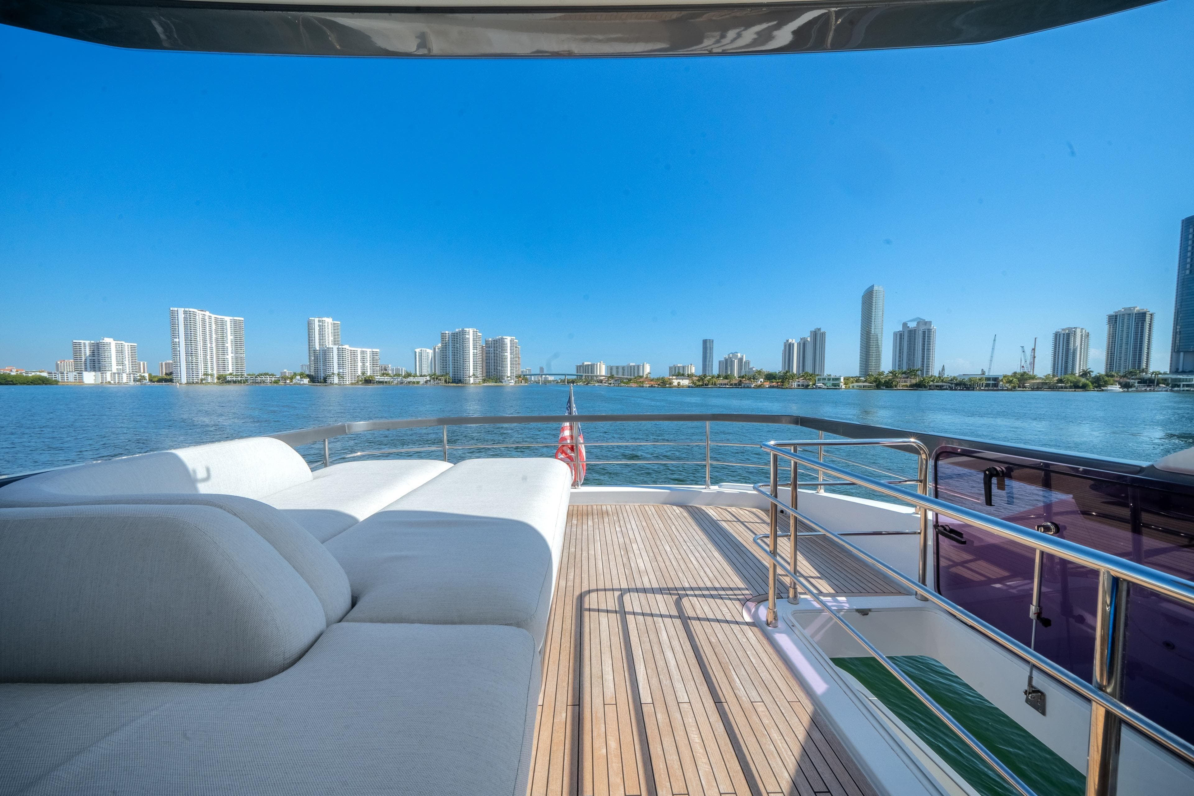 Luxurious 2023 Azimut Fly 68 yacht deck with city skyline view.