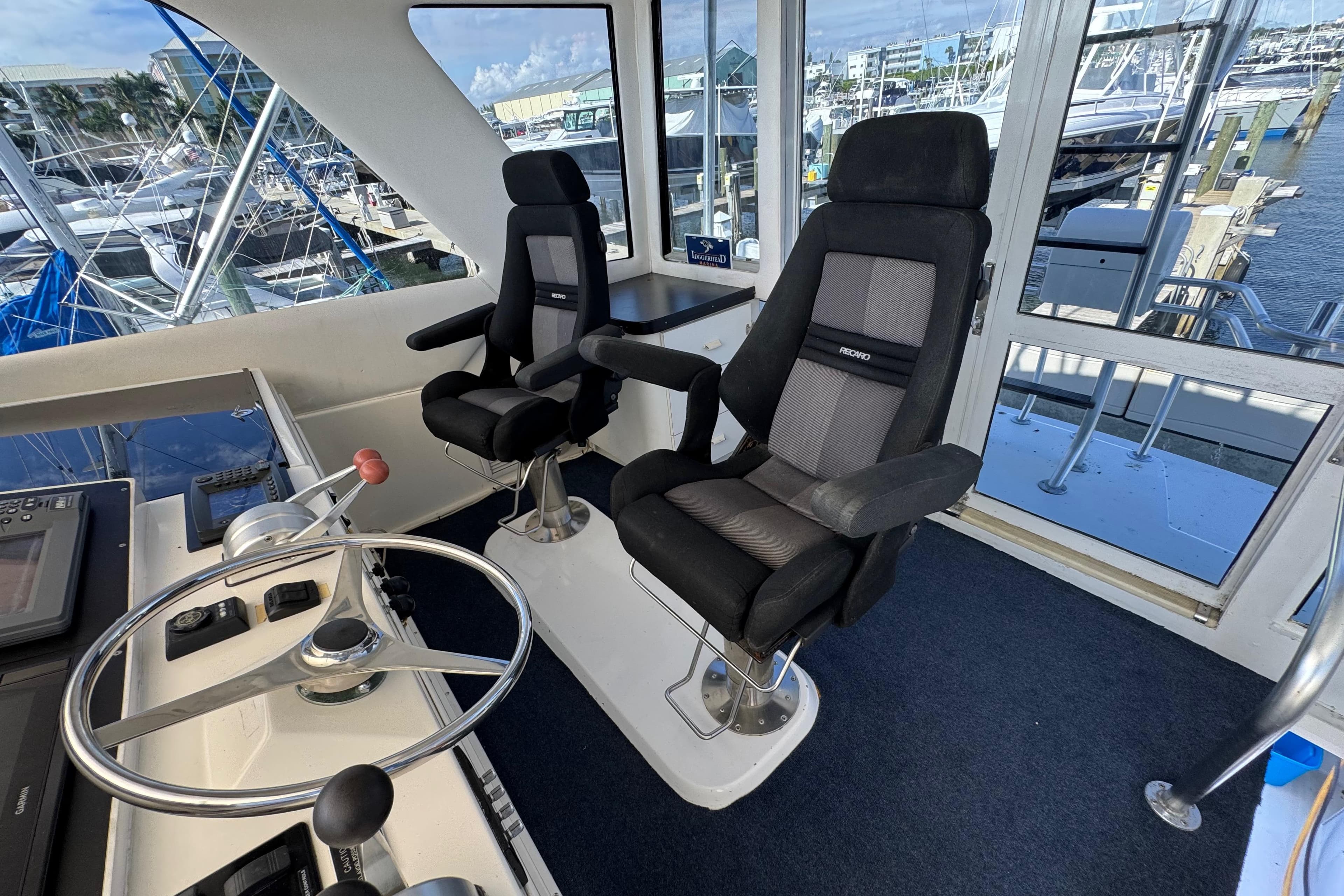 Interior of 1995 Viking 58 Convertible yacht with helm and two captain chairs.