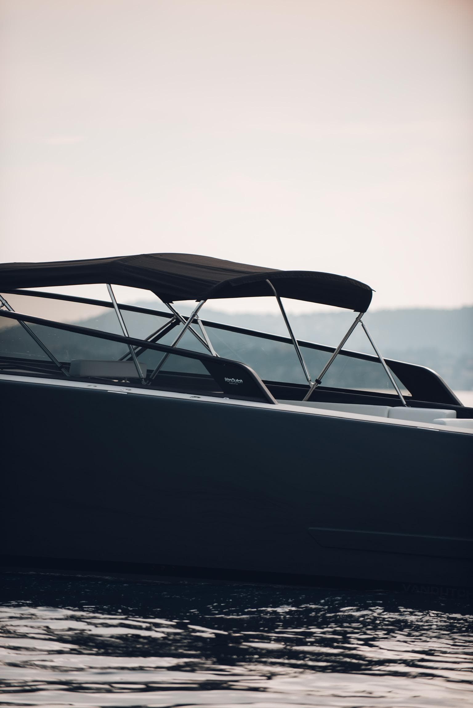 2022 VanDutch 48s luxury yacht on calm water at sunset.