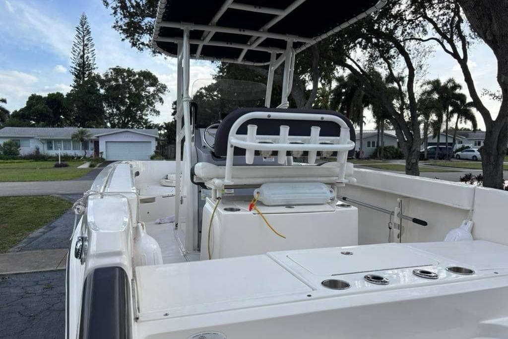 2023 Bayliner Trophy T22CC boat with seating and rod holders, parked in a residential area.