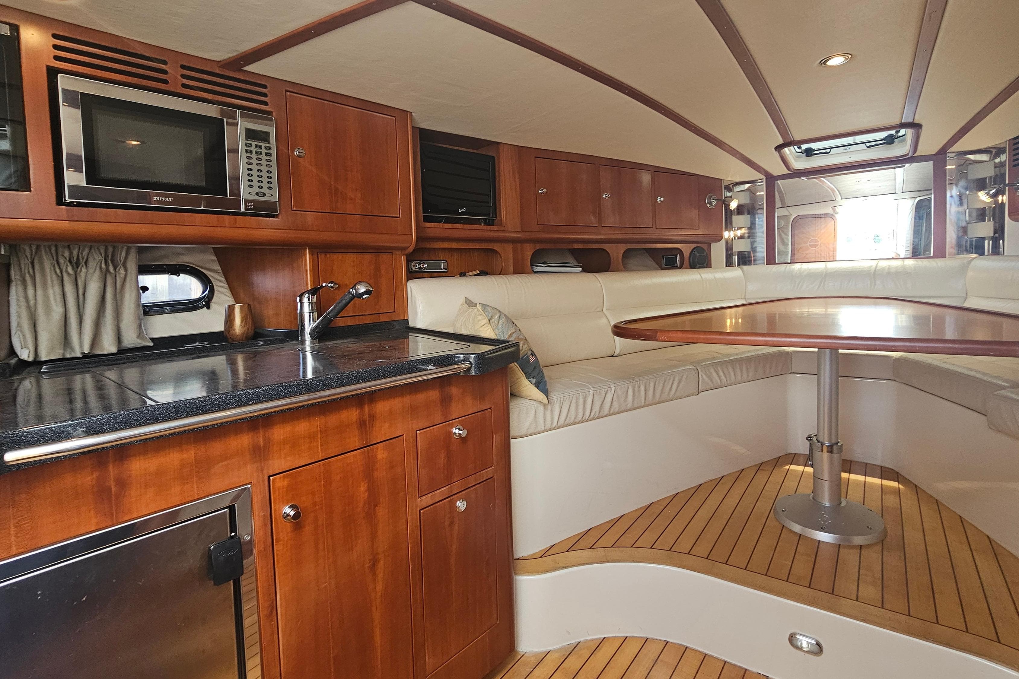 Luxurious 2006 Chris-Craft Corsair 36 interior with wood cabinetry and cozy seating area.