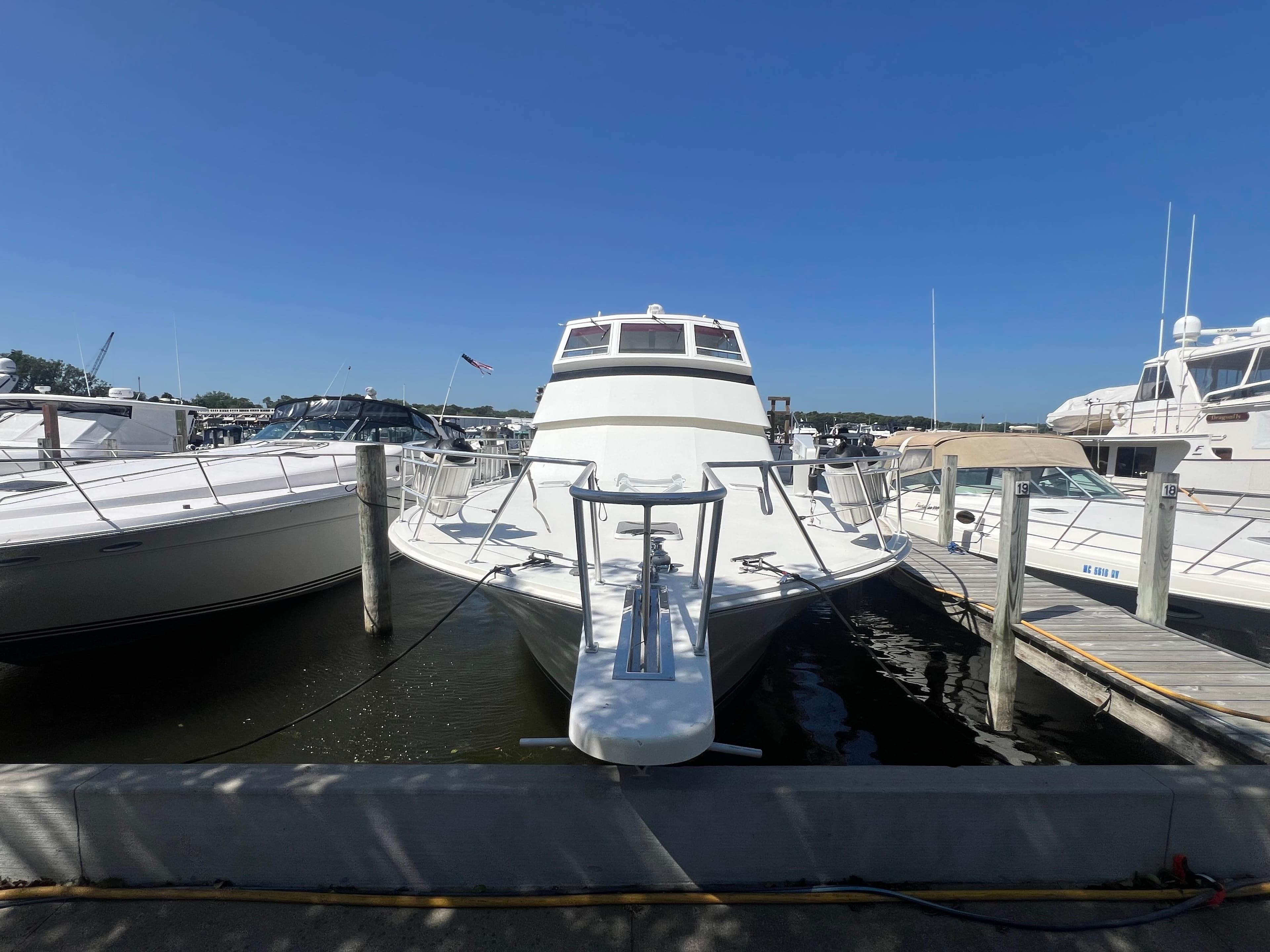 1995 Viking Sports Yacht docked at marina under clear blue sky.
