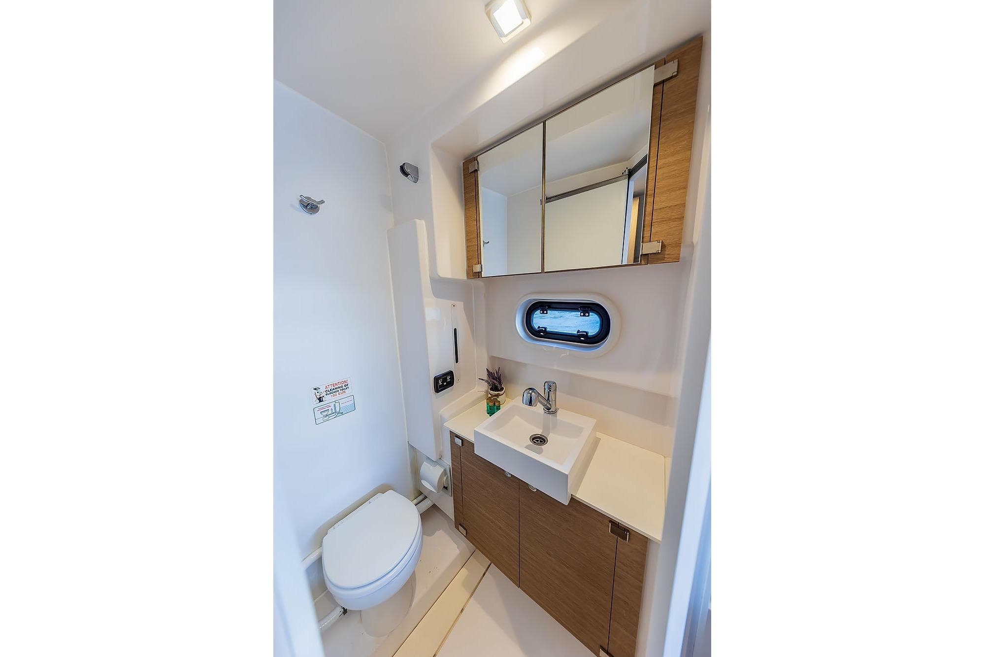 Modern bathroom interior on 2018 Bali 4.1 yacht, featuring sink, toilet, and mirror cabinet.
