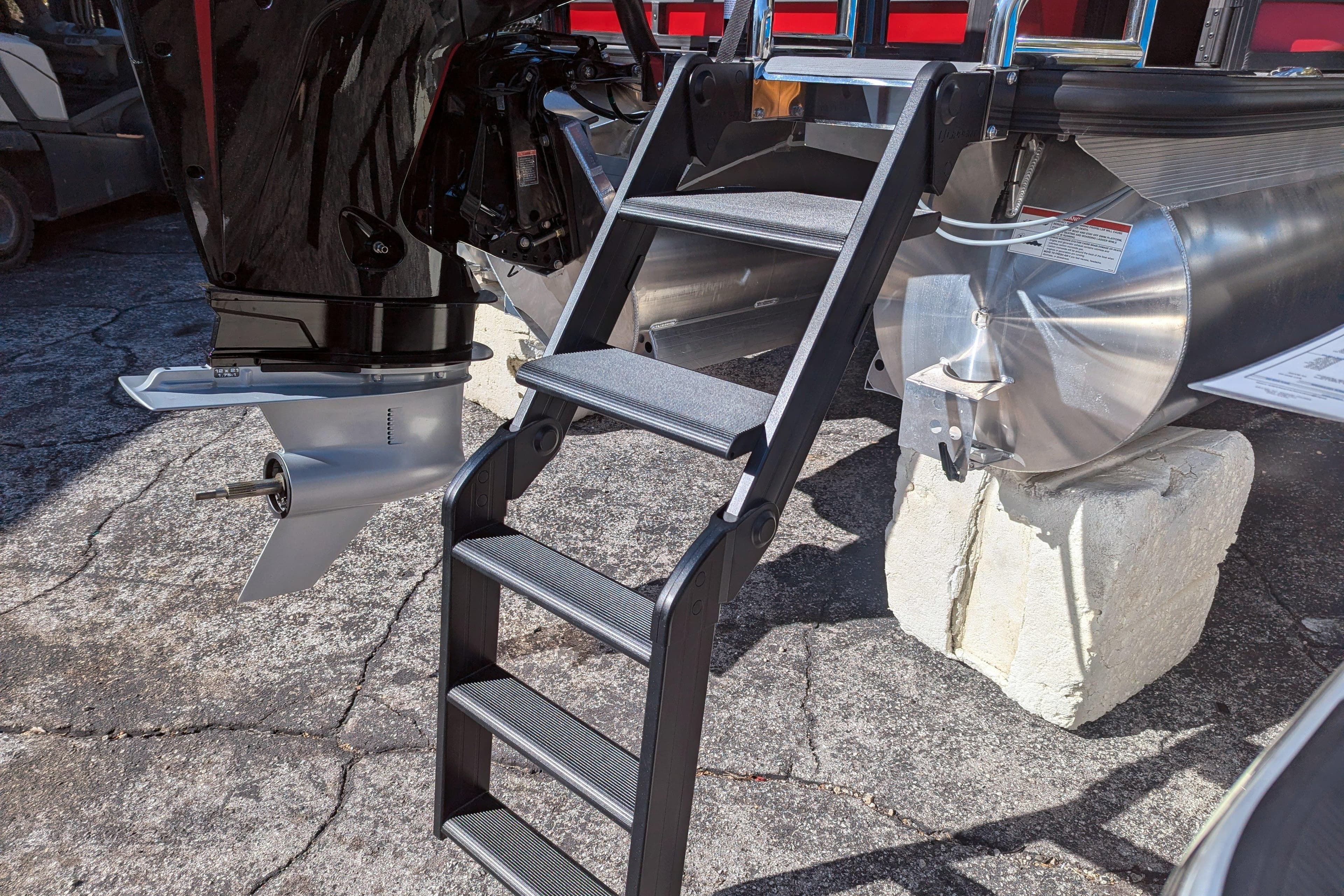 Ladder and motor of 2026 Trifecta 21C SS pontoon boat on display.