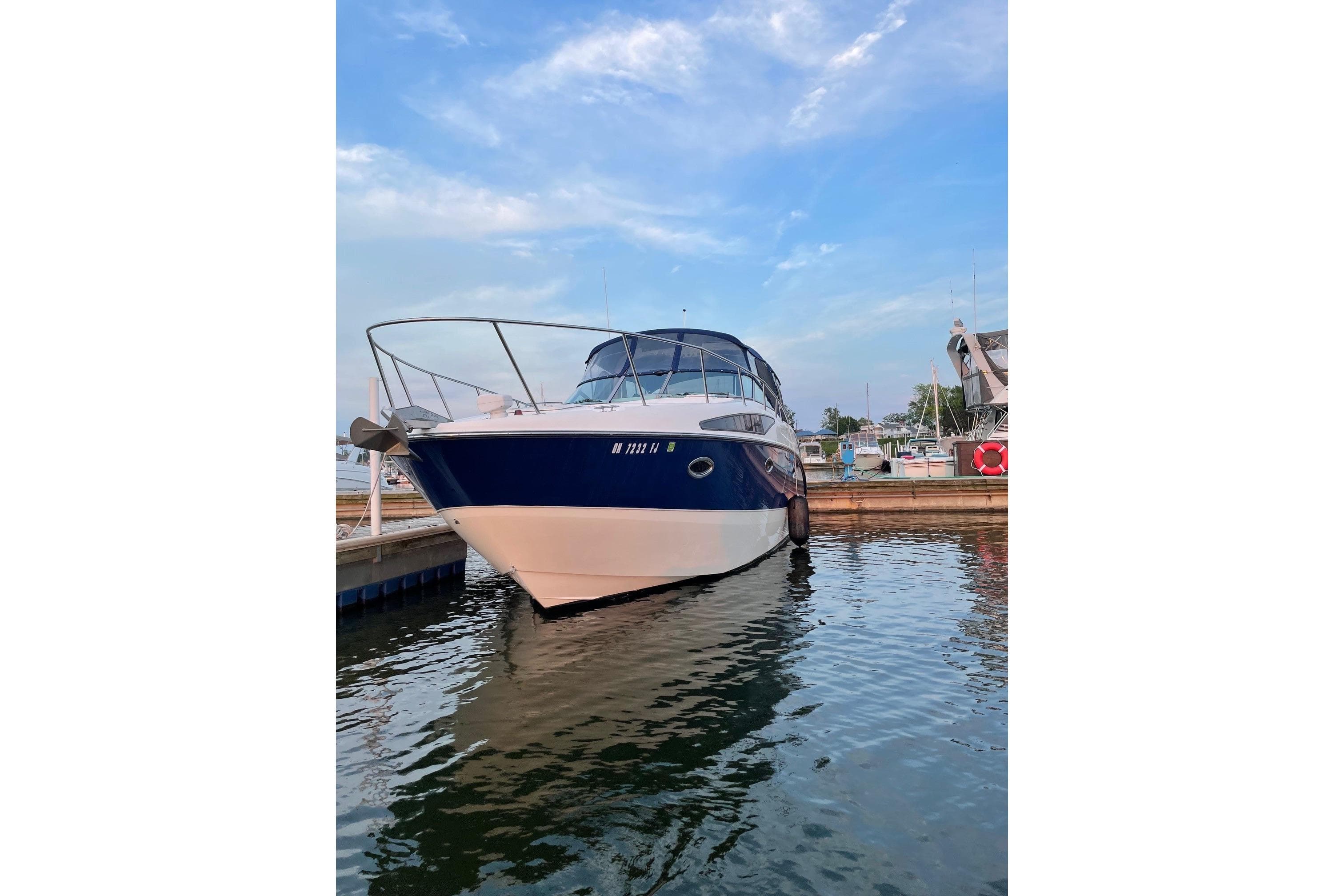 2007 Bayliner 325 boat docked in marina under blue sky.