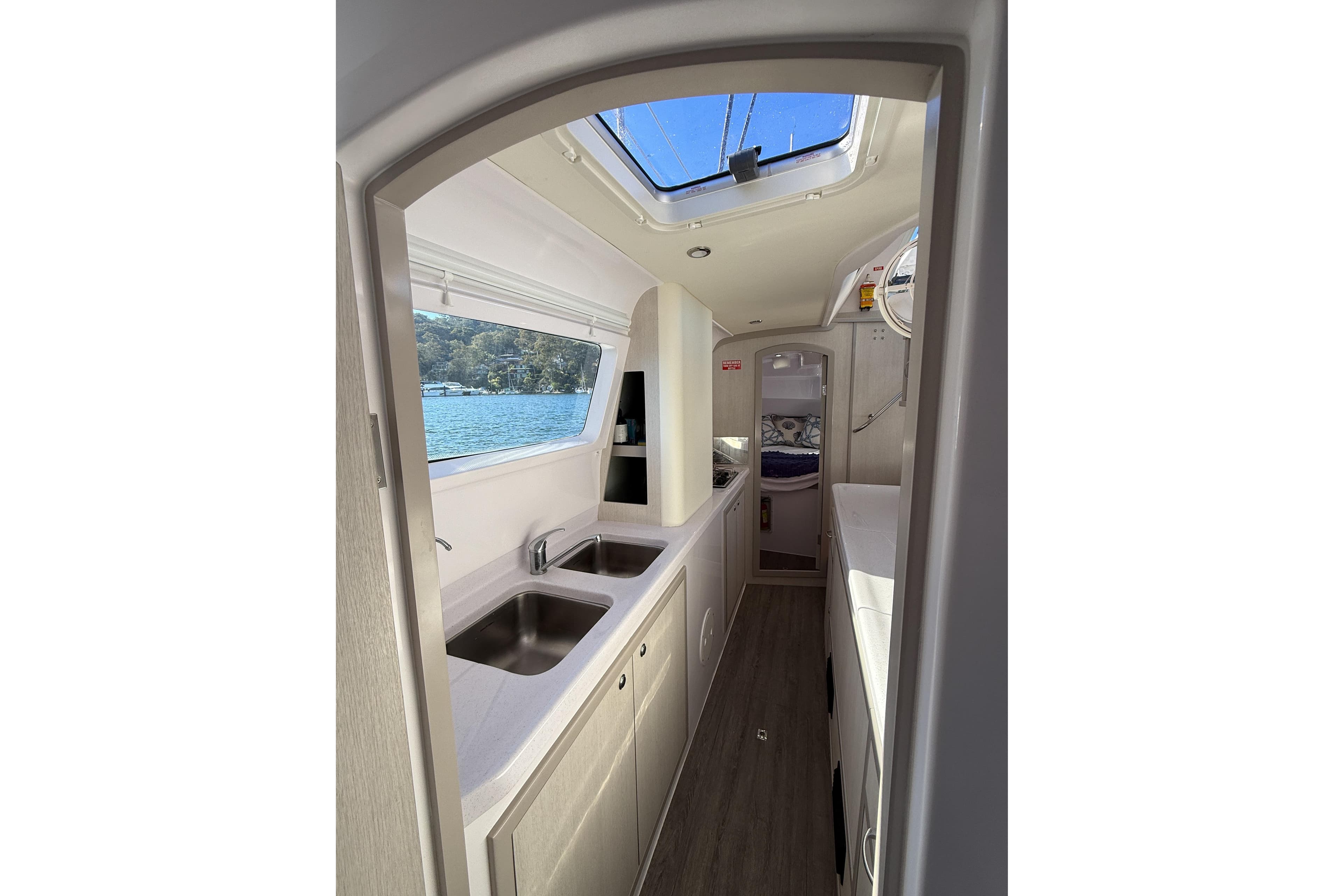 Interior of 2019 Seawind 1190 catamaran, featuring modern kitchen and scenic window view.