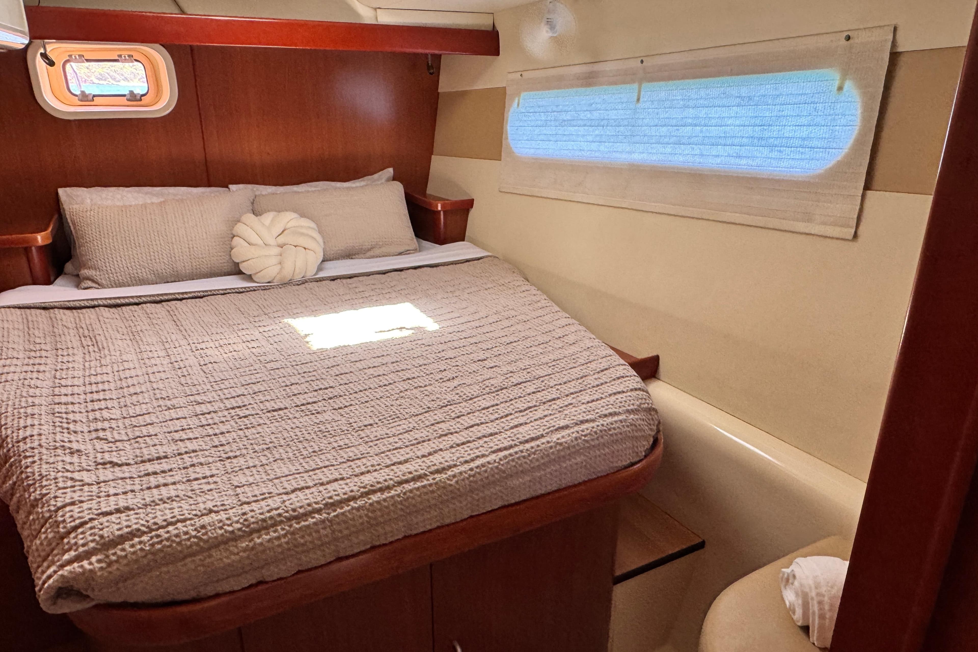 Cozy bedroom interior of 2011 Leopard 46 yacht with plush bedding and natural light.