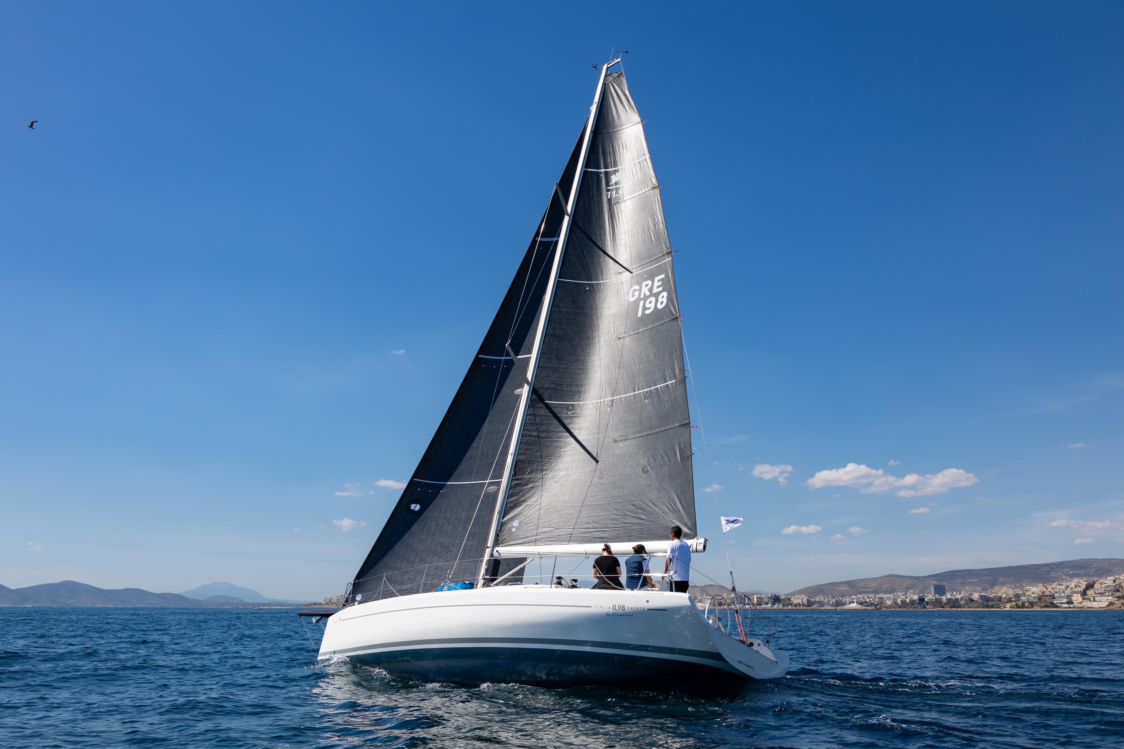 Italia Yachts IY11.98 Bellissima 2023 sailing on open sea under clear blue sky.