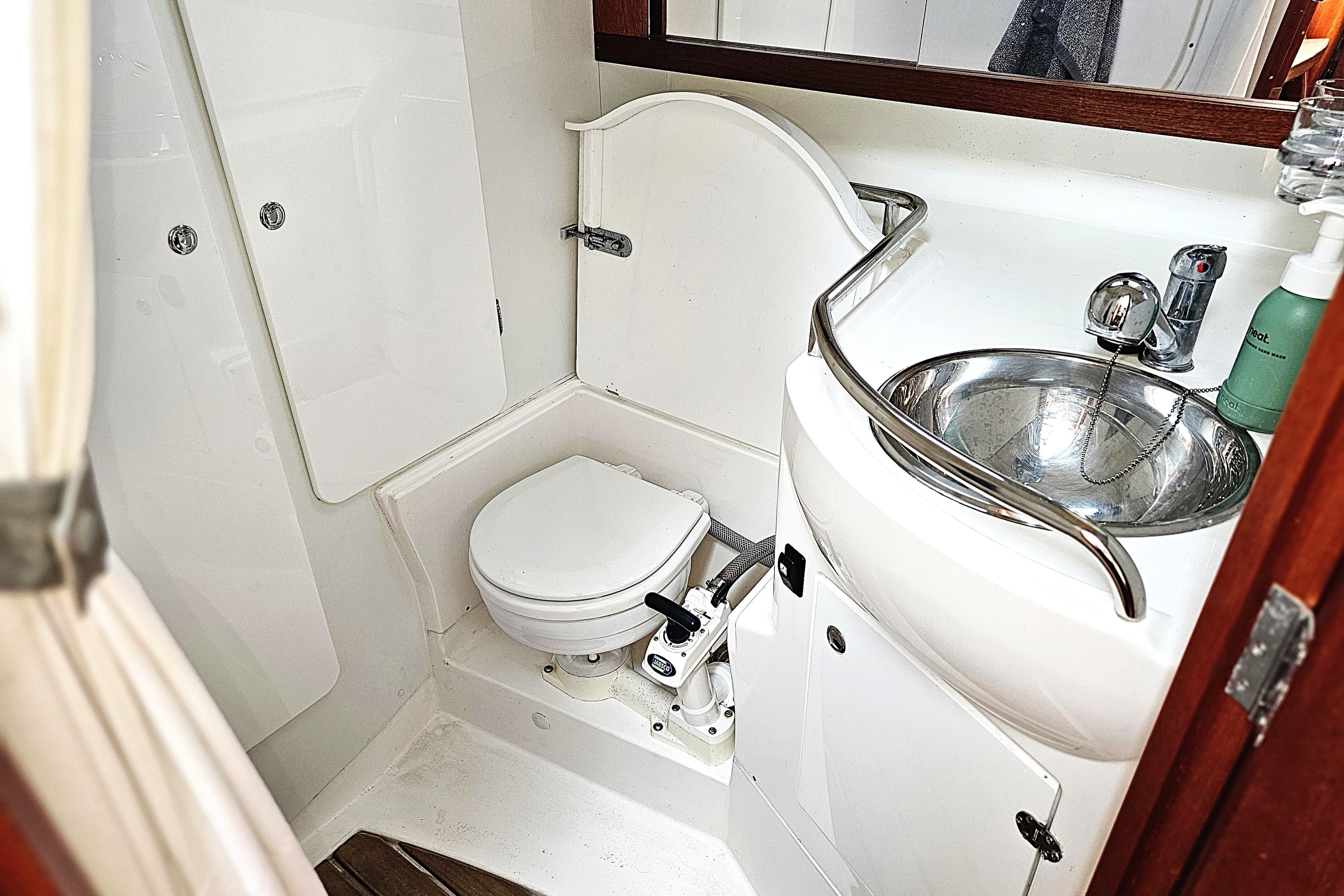 Compact boat bathroom with toilet and stainless steel sink, Maxi 1100, 2006 model.
