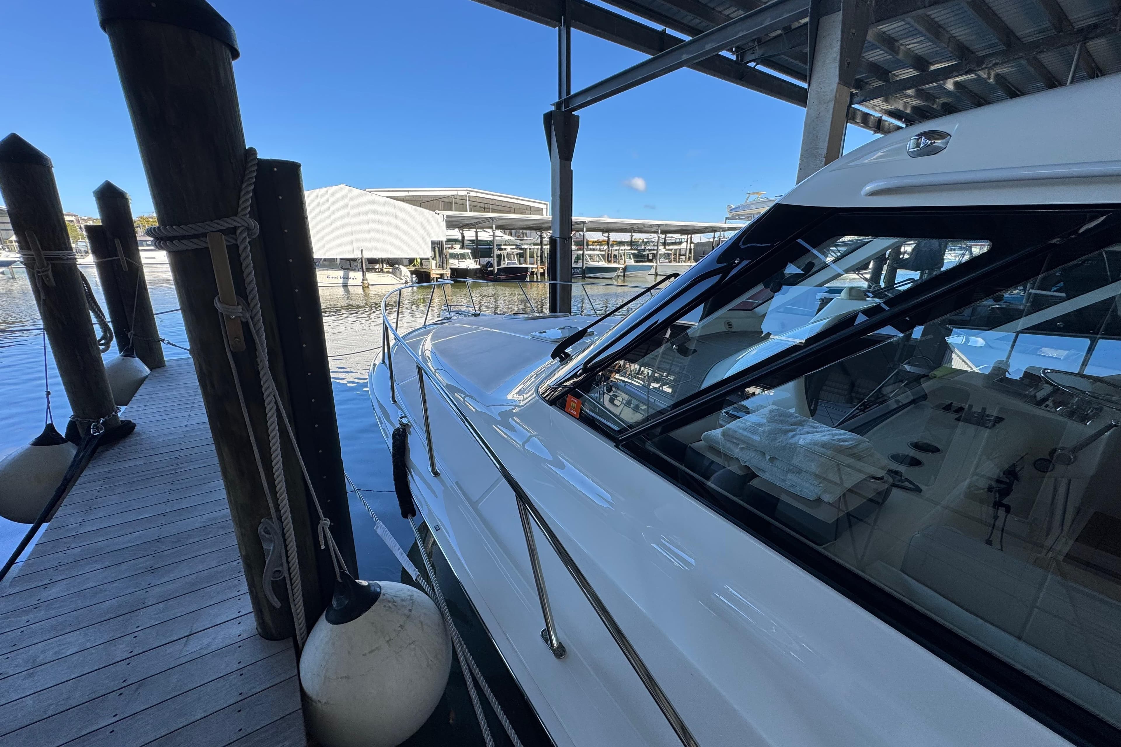 2013 Cabo 44 Hardtop Express yacht docked in a marina under a covered structure.