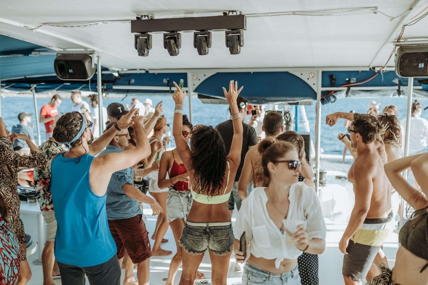 People dancing on a 2015 Fountaine Pajot TAHITI catamaran during a lively boat party.