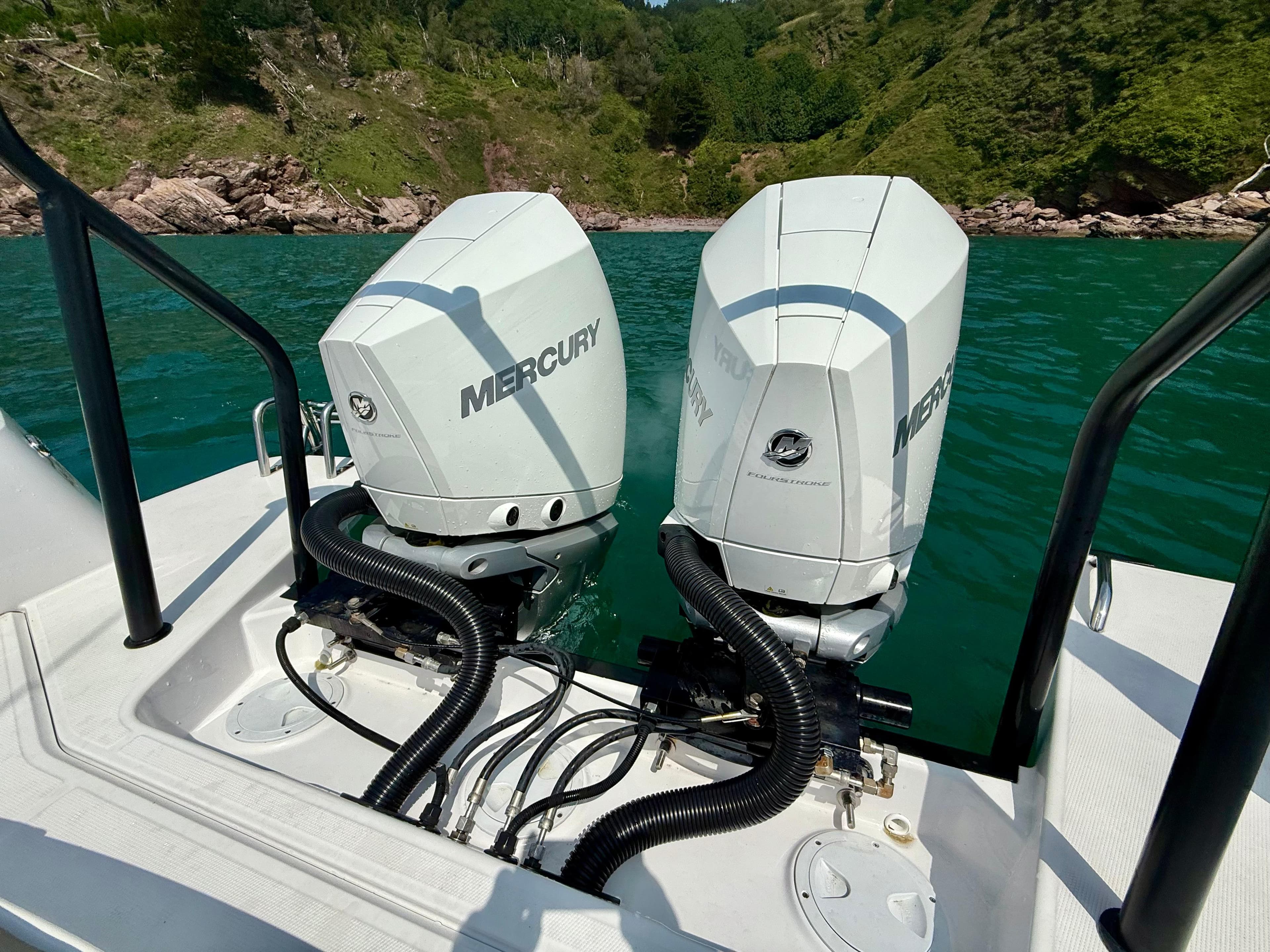 Twin Mercury outboard engines on 2020 Axopar 37 Cross Cabin, scenic lake backdrop.