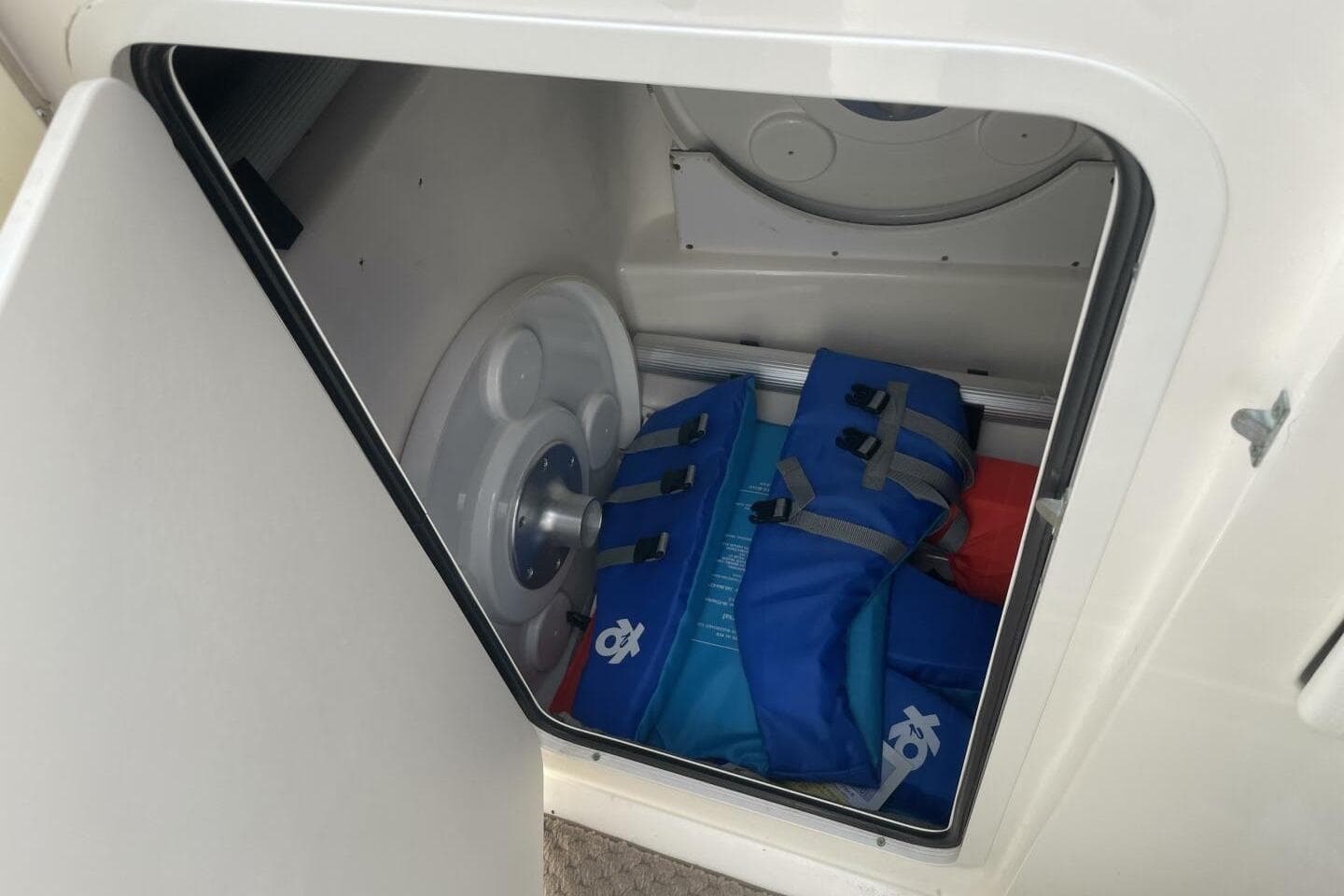 Storage compartment in 2008 Sea Ray 270 SLX boat with life jackets and equipment.