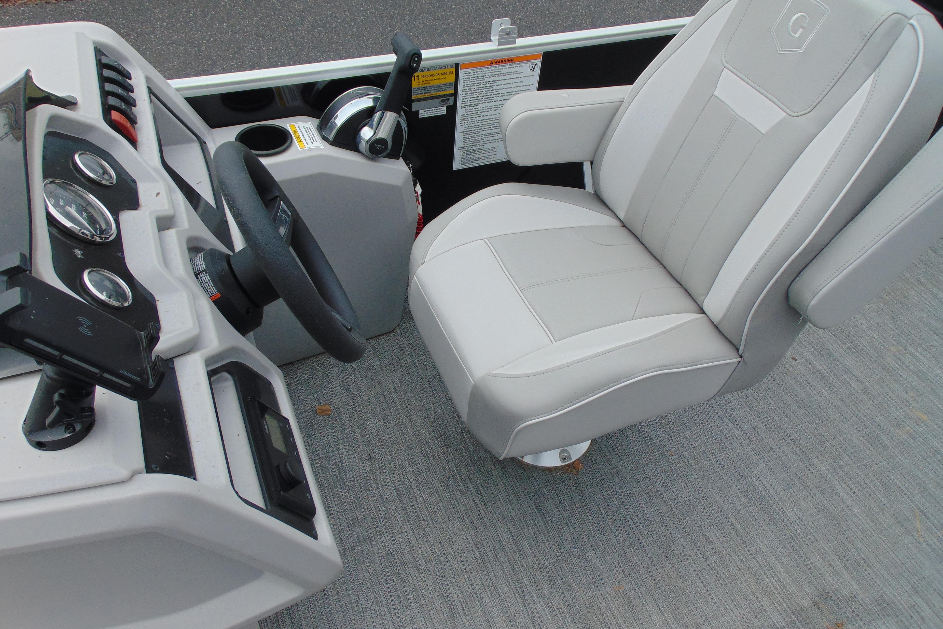 2024 Godfrey Sweetwater 2086 C boat interior with steering wheel and captain's chair.