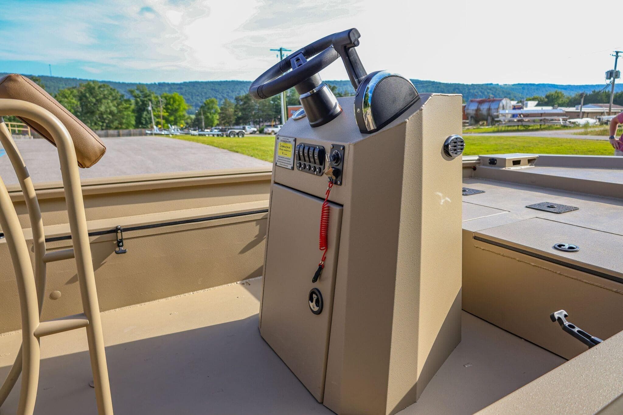 2026 Excel Switchblade boat console with steering wheel, outdoors on a sunny day.