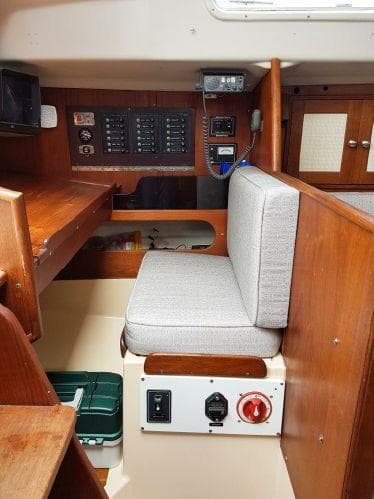 1977 Ontario Yachts 32 interior with control panel, cushioned seating, and wooden cabinetry.
