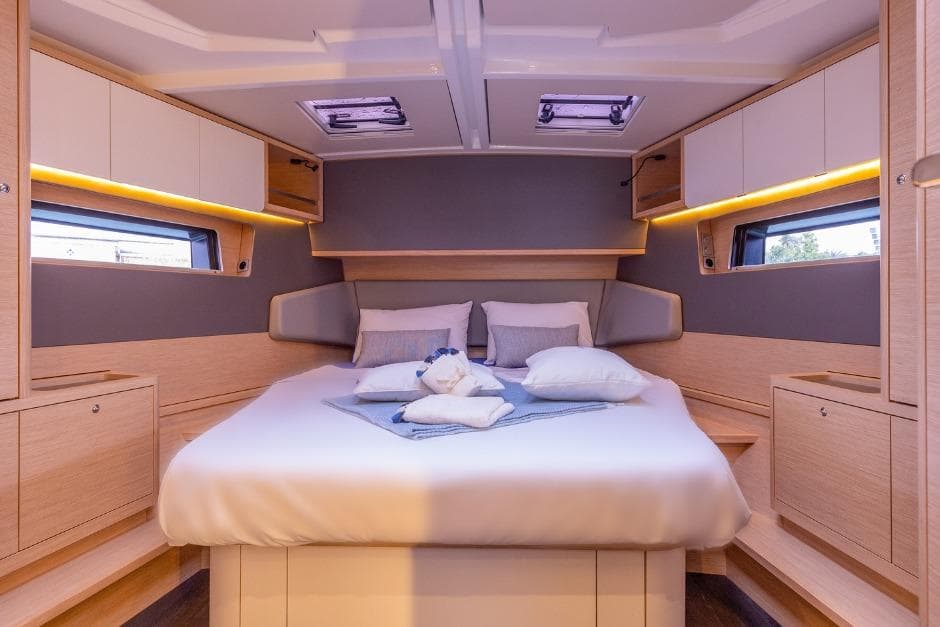 Luxurious cabin interior of 2026 Dufour 48 yacht with modern design and cozy bedding.