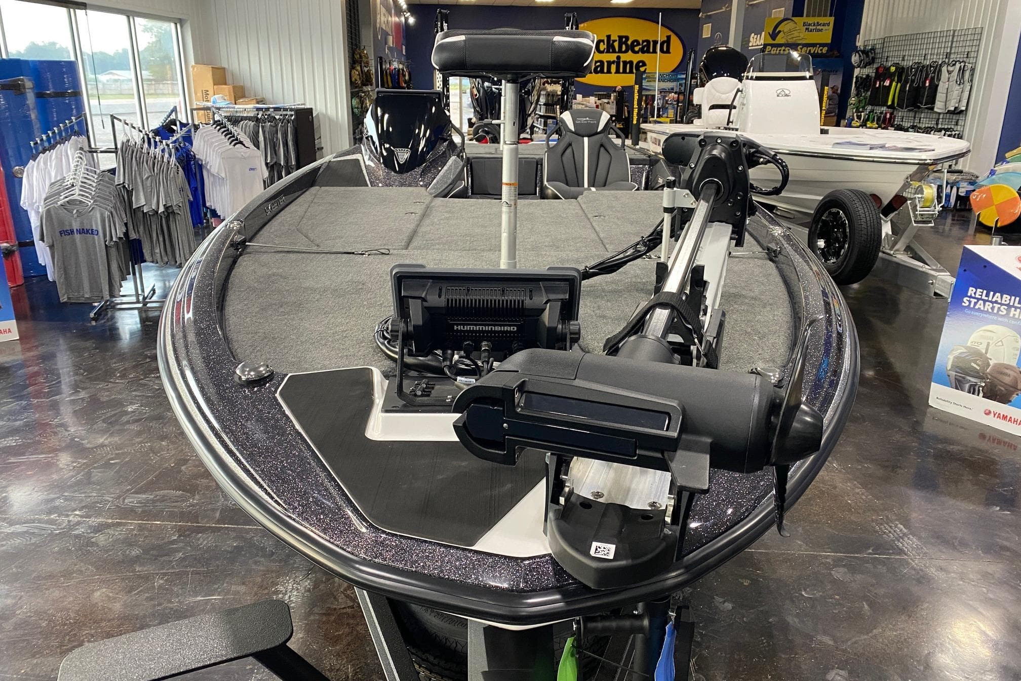 2026 Skeeter ZXE21 boat displayed in showroom with fishing equipment.