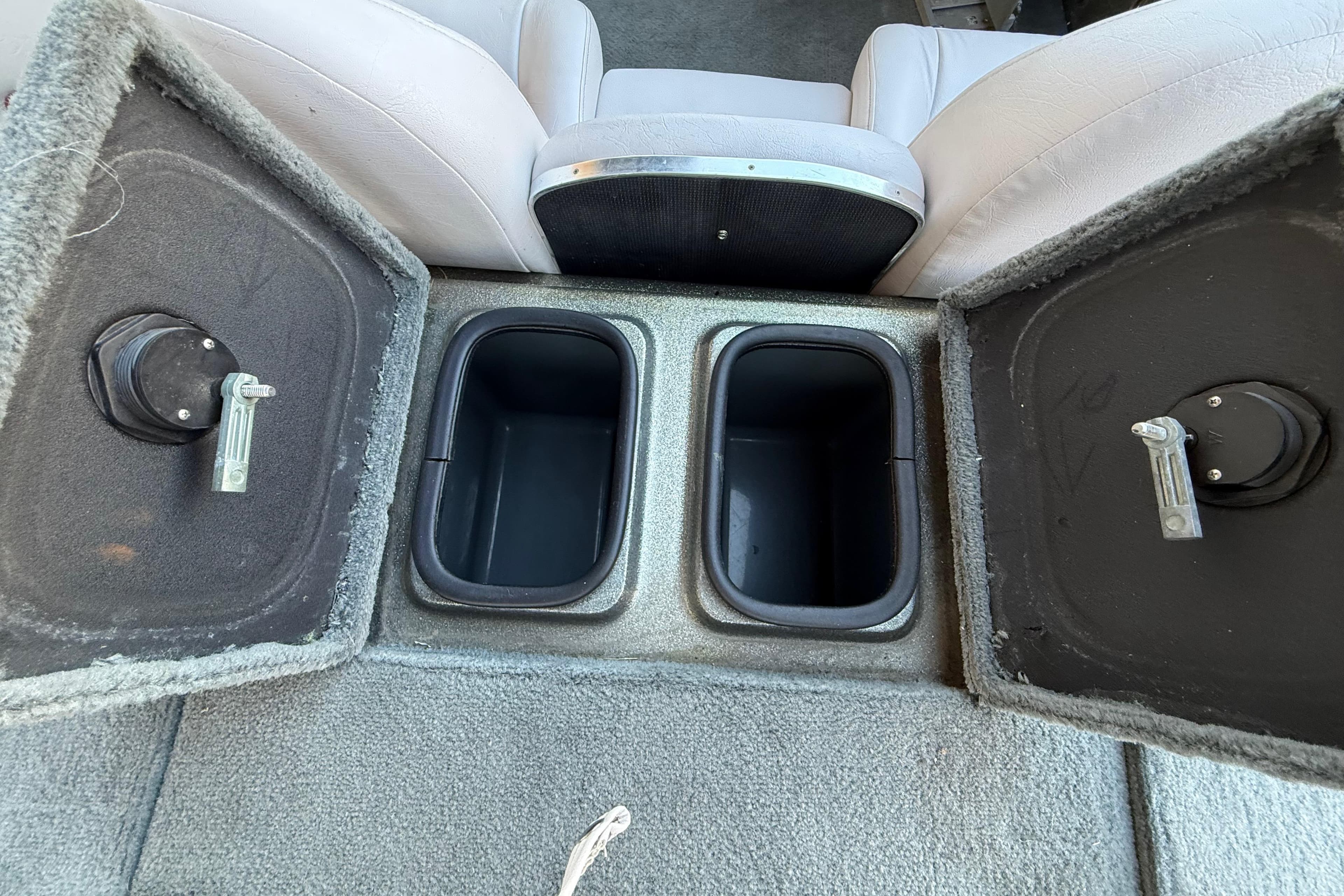 2005 Bass Cat Puma boat storage compartments with open lids and seating.