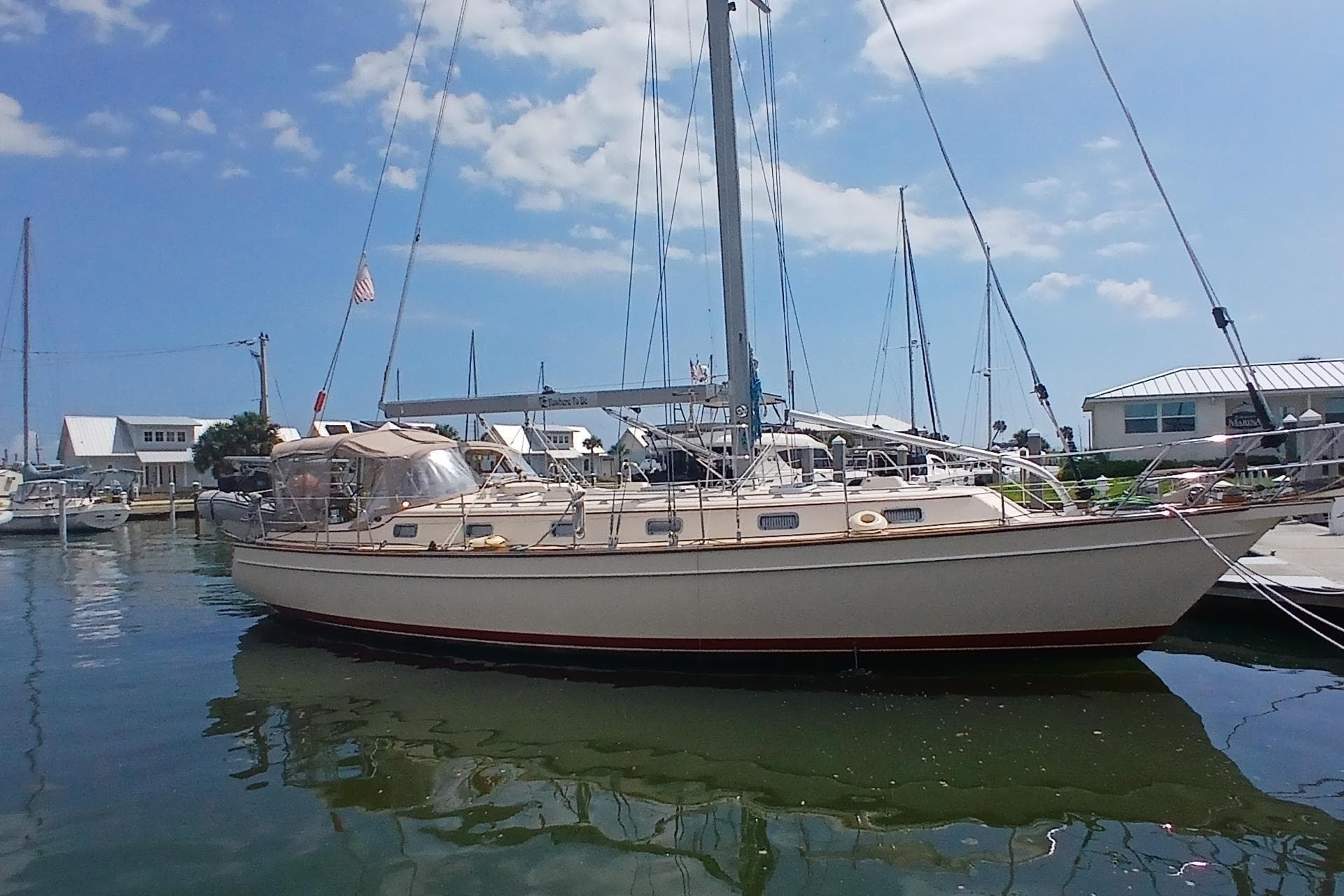 2006 Island Packet 440 sailboat docked at marina under clear blue sky.