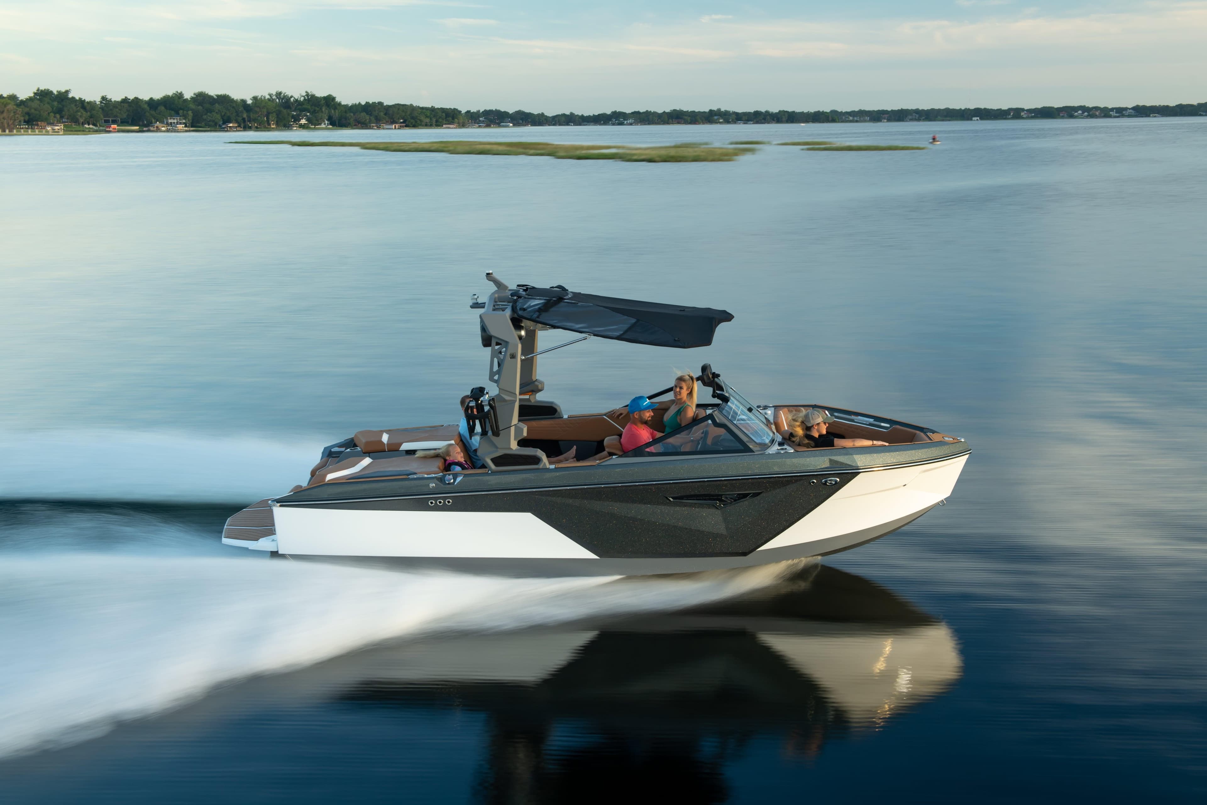 2026 Nautique S21 boat cruising on a calm lake with passengers enjoying the ride.