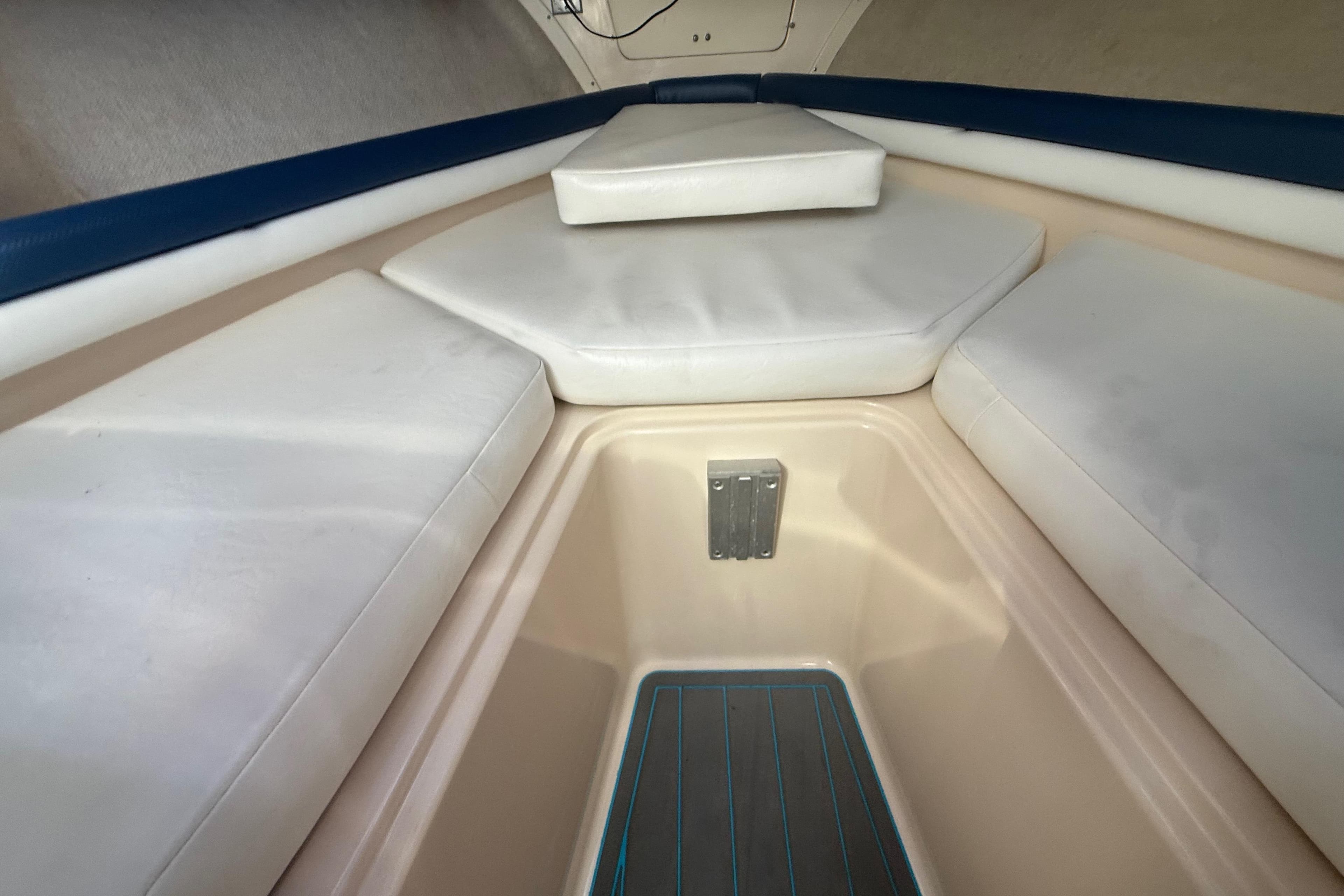 Interior cabin of 1996 Grady-White Sailfish 272 with cushioned seating and storage area.