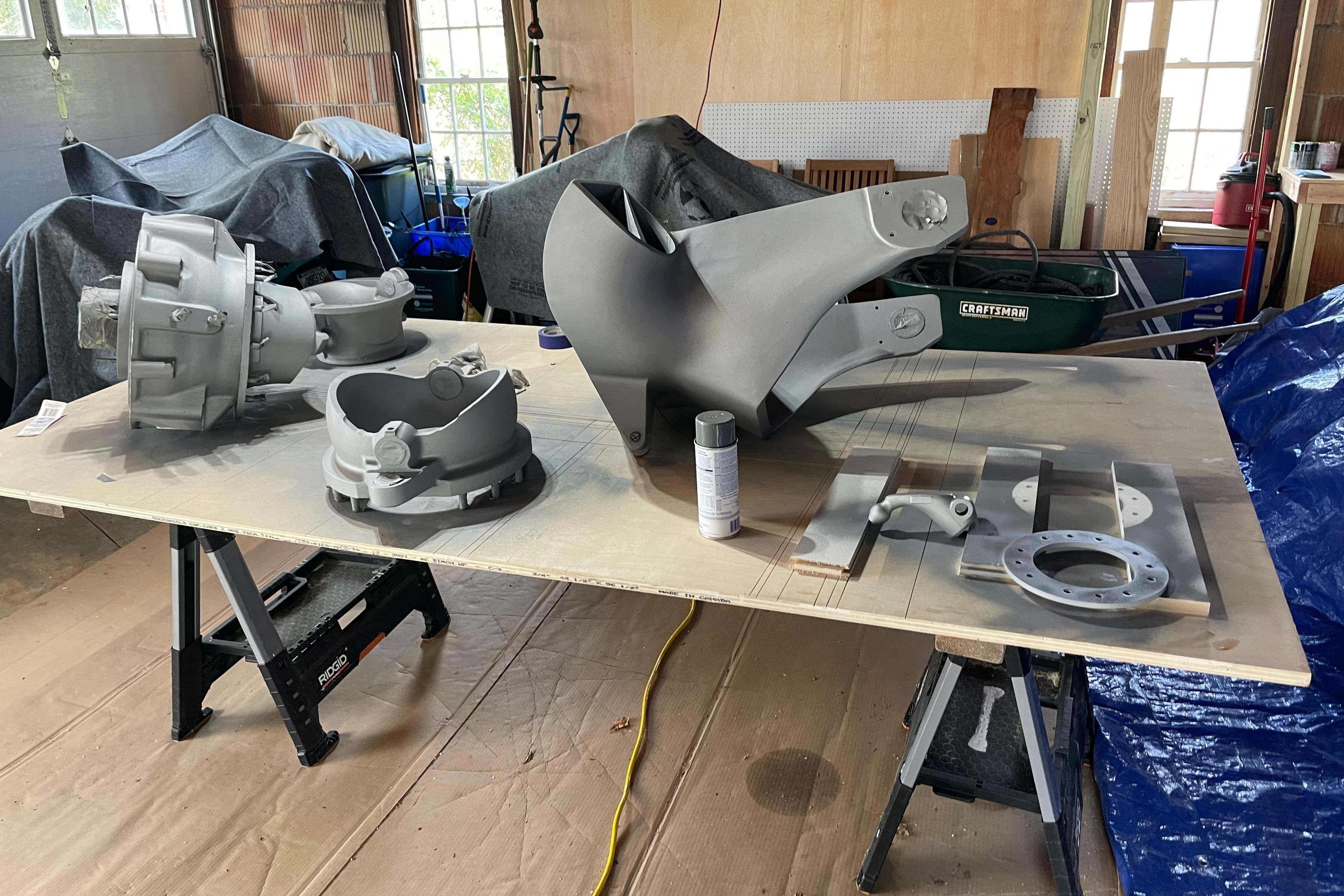 Boat parts from a 2005 Lyman-Morse Monhegan, displayed on a workbench in a garage.