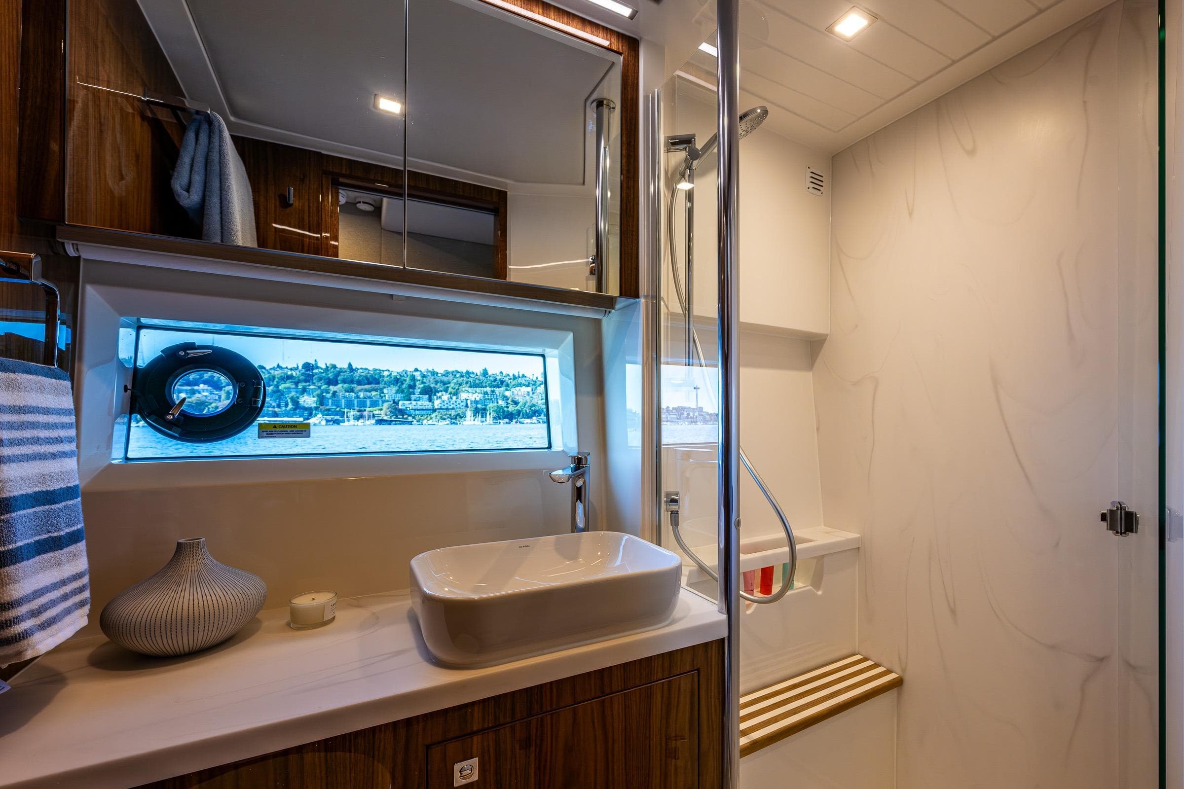 Luxurious bathroom in 2025 Riviera 4600 Sport Yacht with modern fixtures and scenic window view.