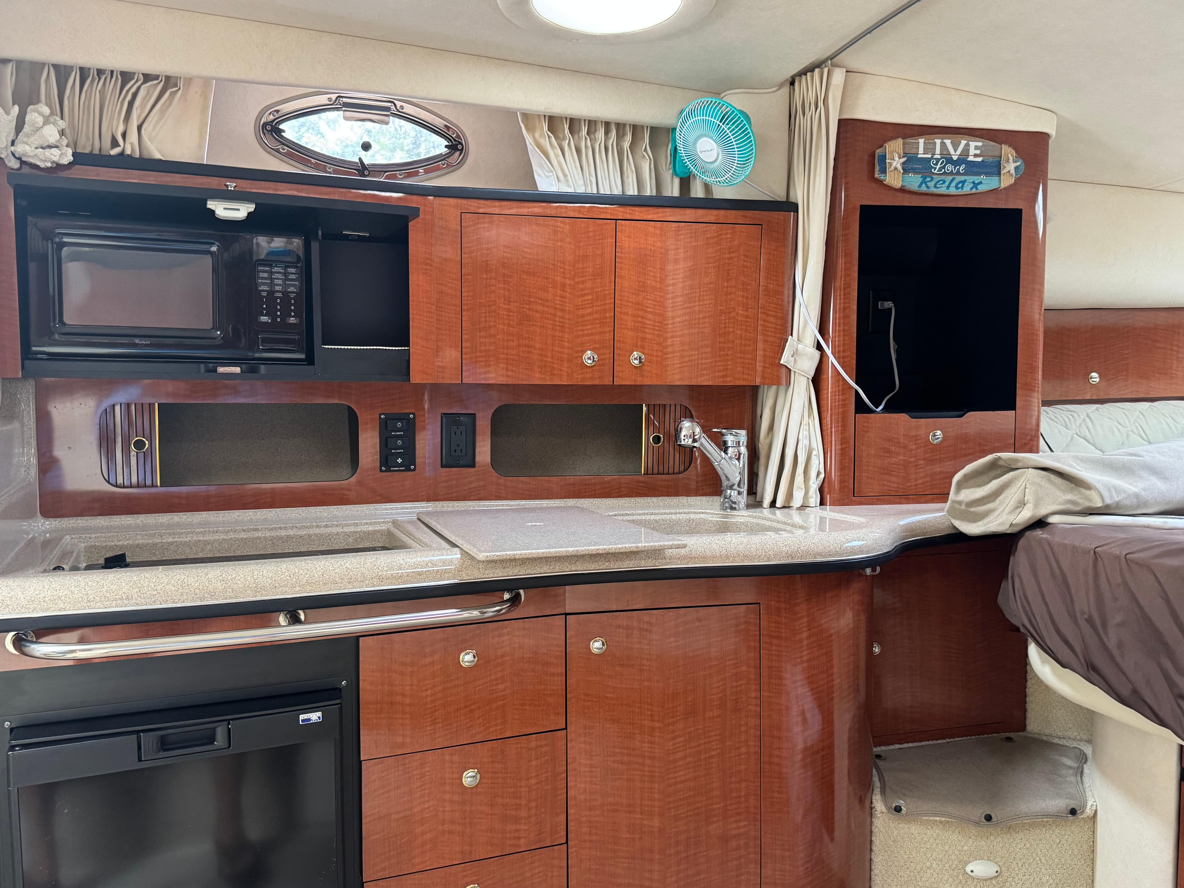 2003 Sea Ray 320 Sundancer interior with kitchenette, microwave, and wooden cabinetry.