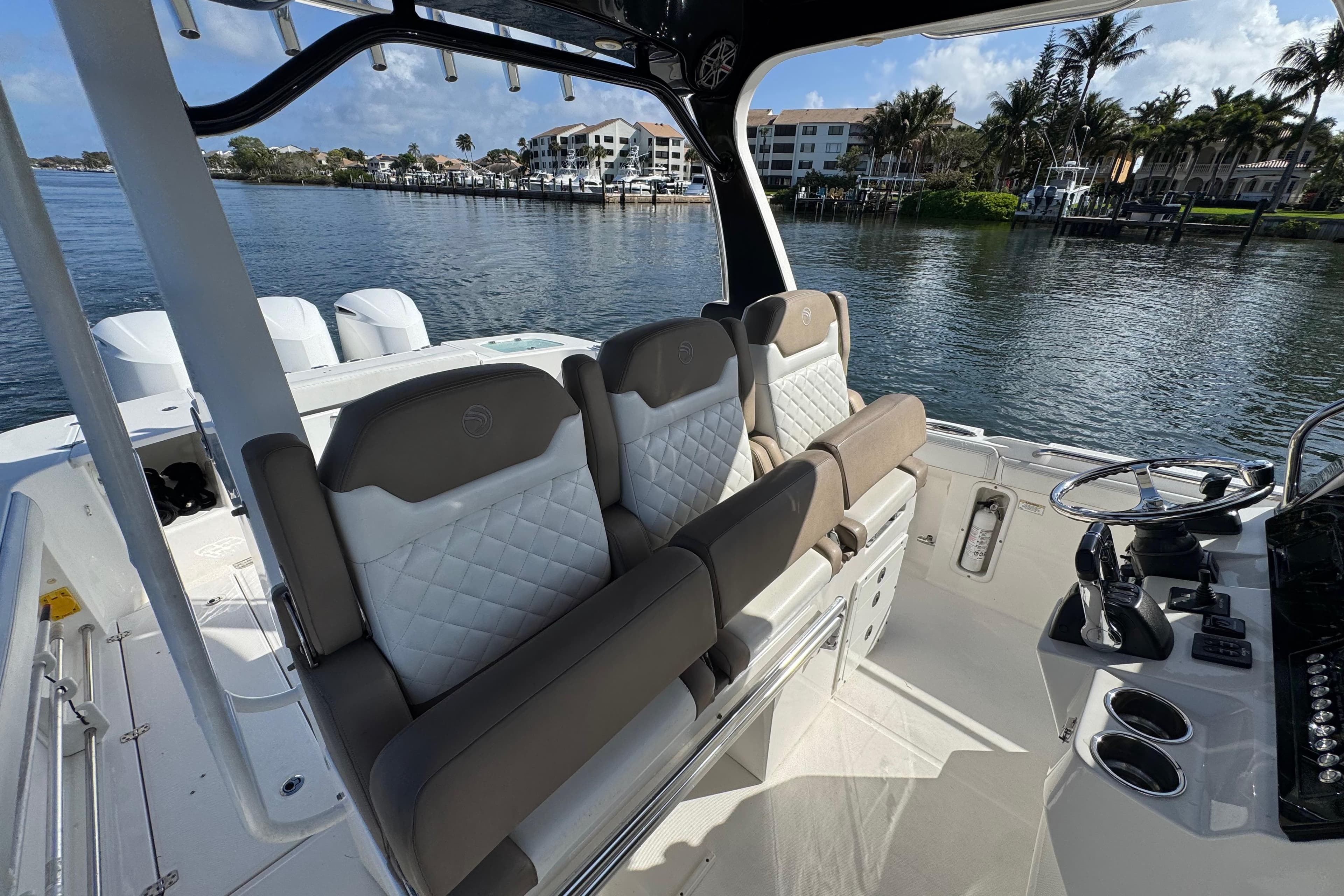 2017 Edgewater 368CC boat interior with luxurious seating and steering console by the water.