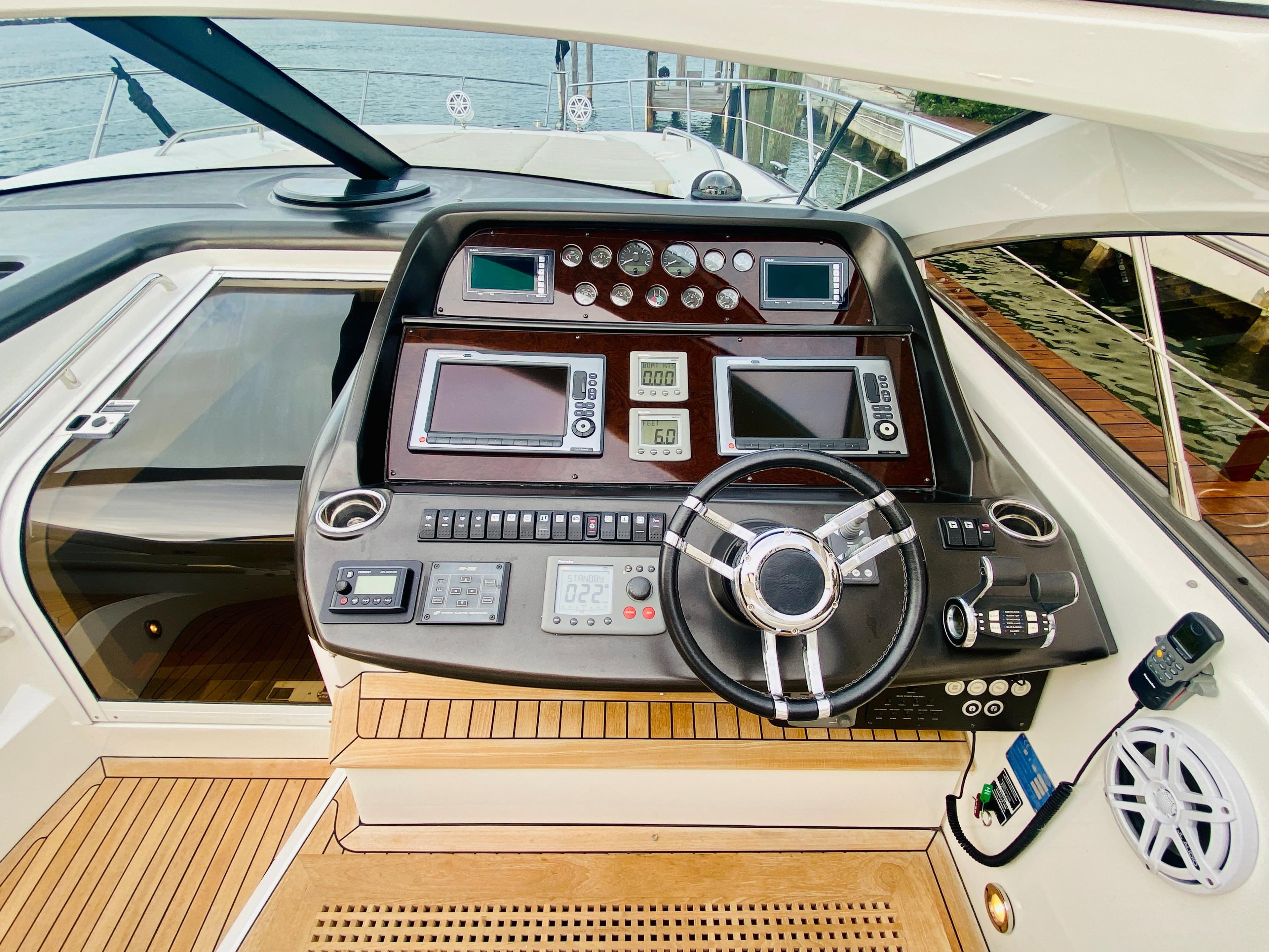 Sunseeker Predator 60 2010 yacht helm with advanced navigation controls and teak flooring.
