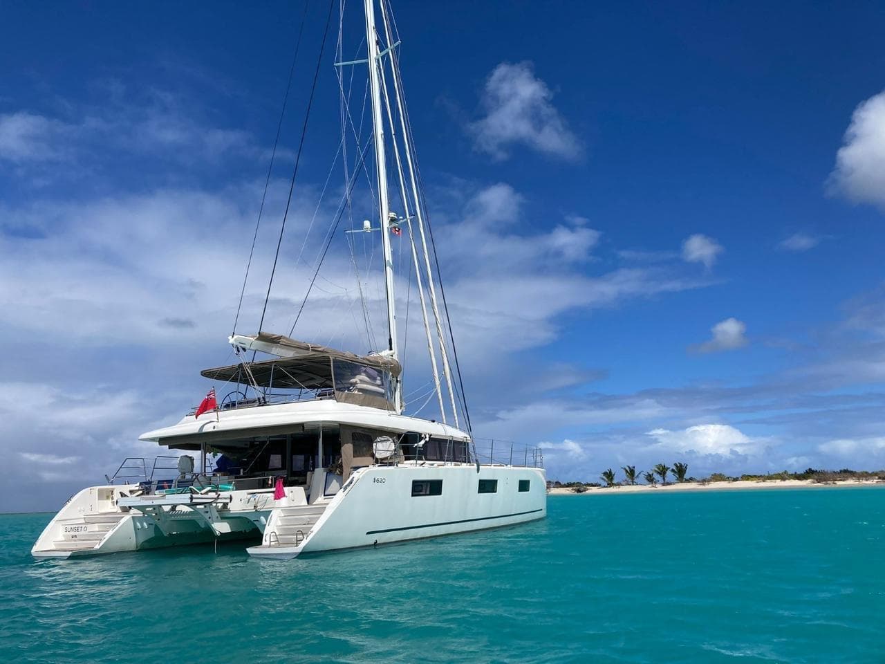 2019 Lagoon 620 catamaran anchored in turquoise waters under a clear blue sky.