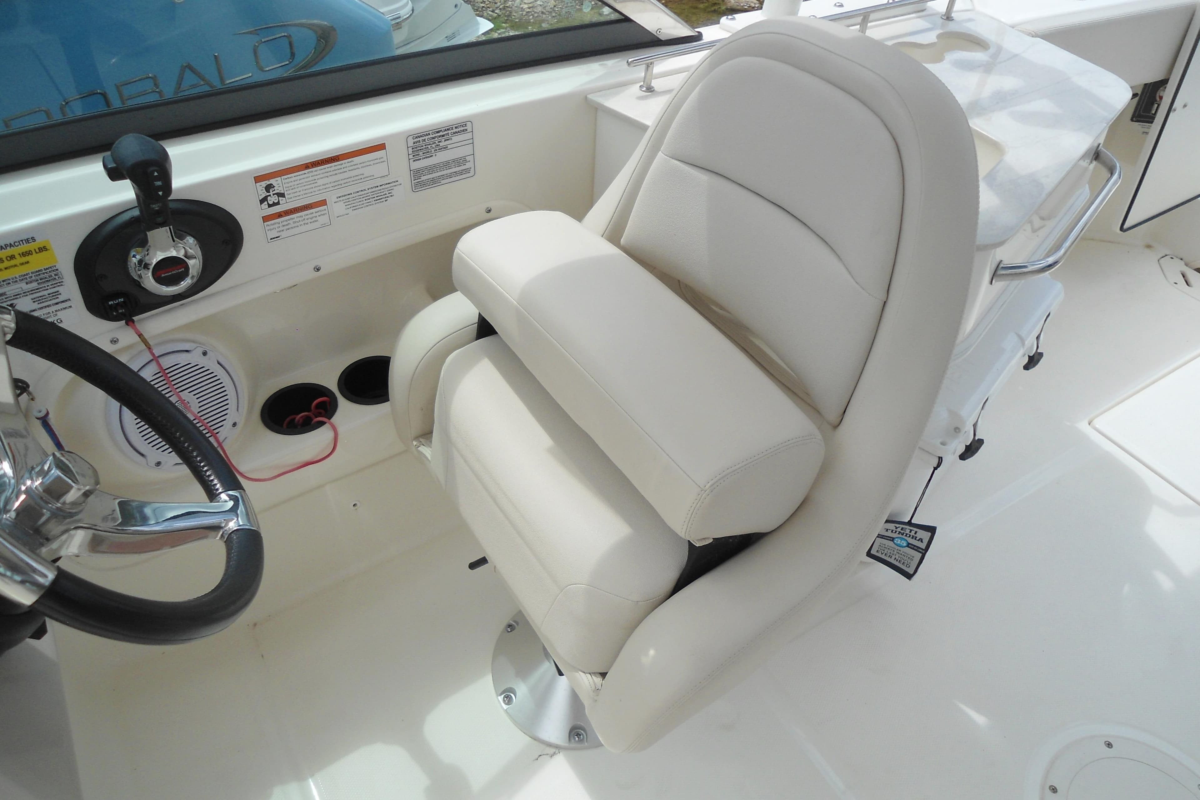 2019 Boston Whaler 230 Vantage boat interior with white captain's chair and steering wheel.