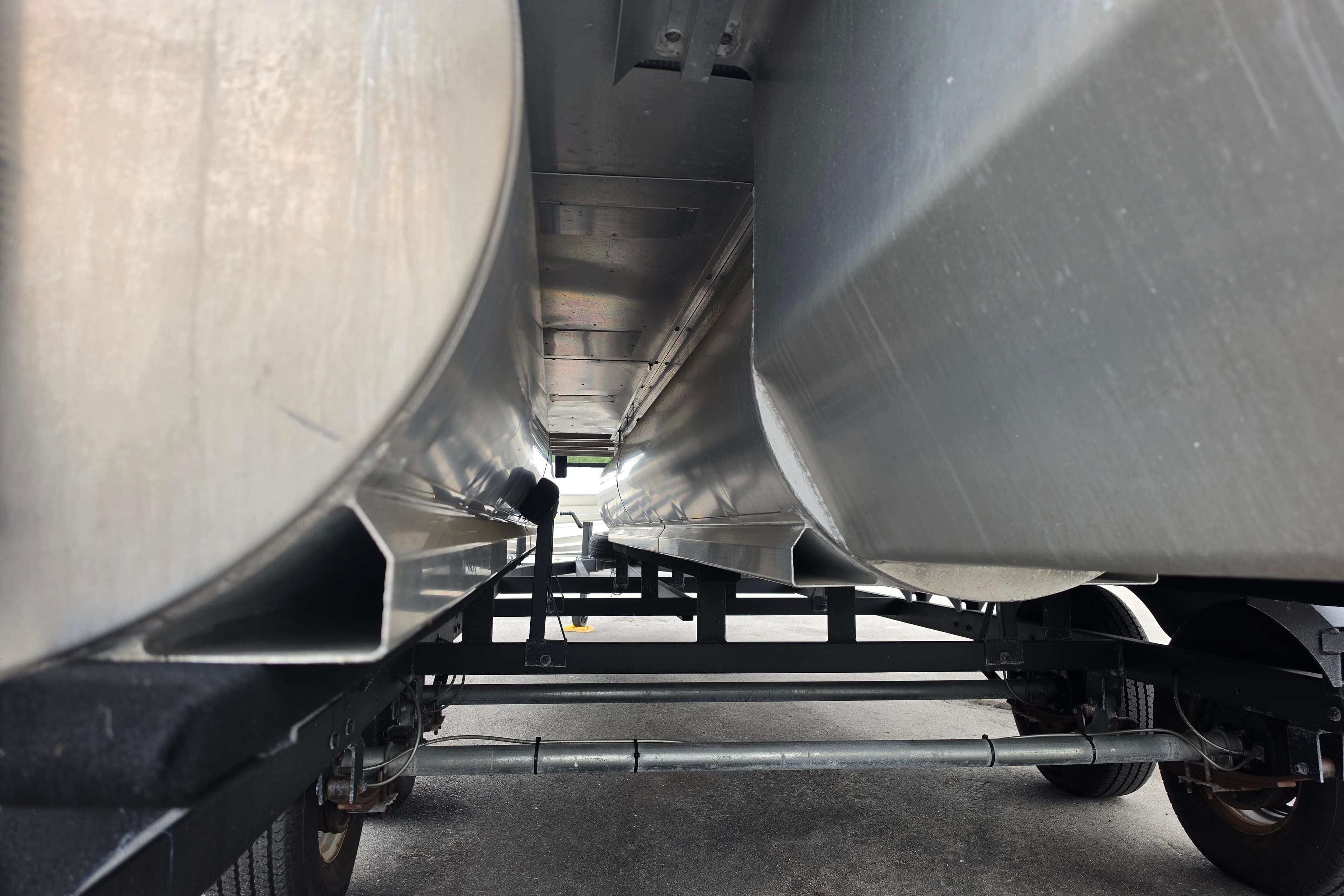 Underneath view of 2023 Sun Tracker Bass Buggy 18 DLX pontoon boat on trailer.