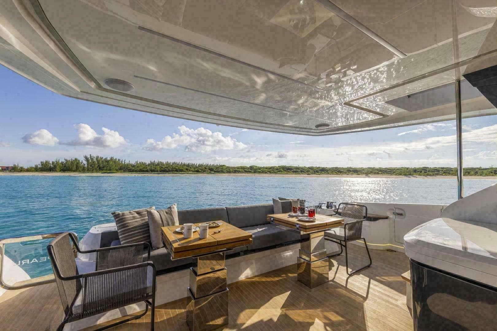 Luxurious Pearl 72 yacht deck with seating, table, and ocean view, 2023 model.