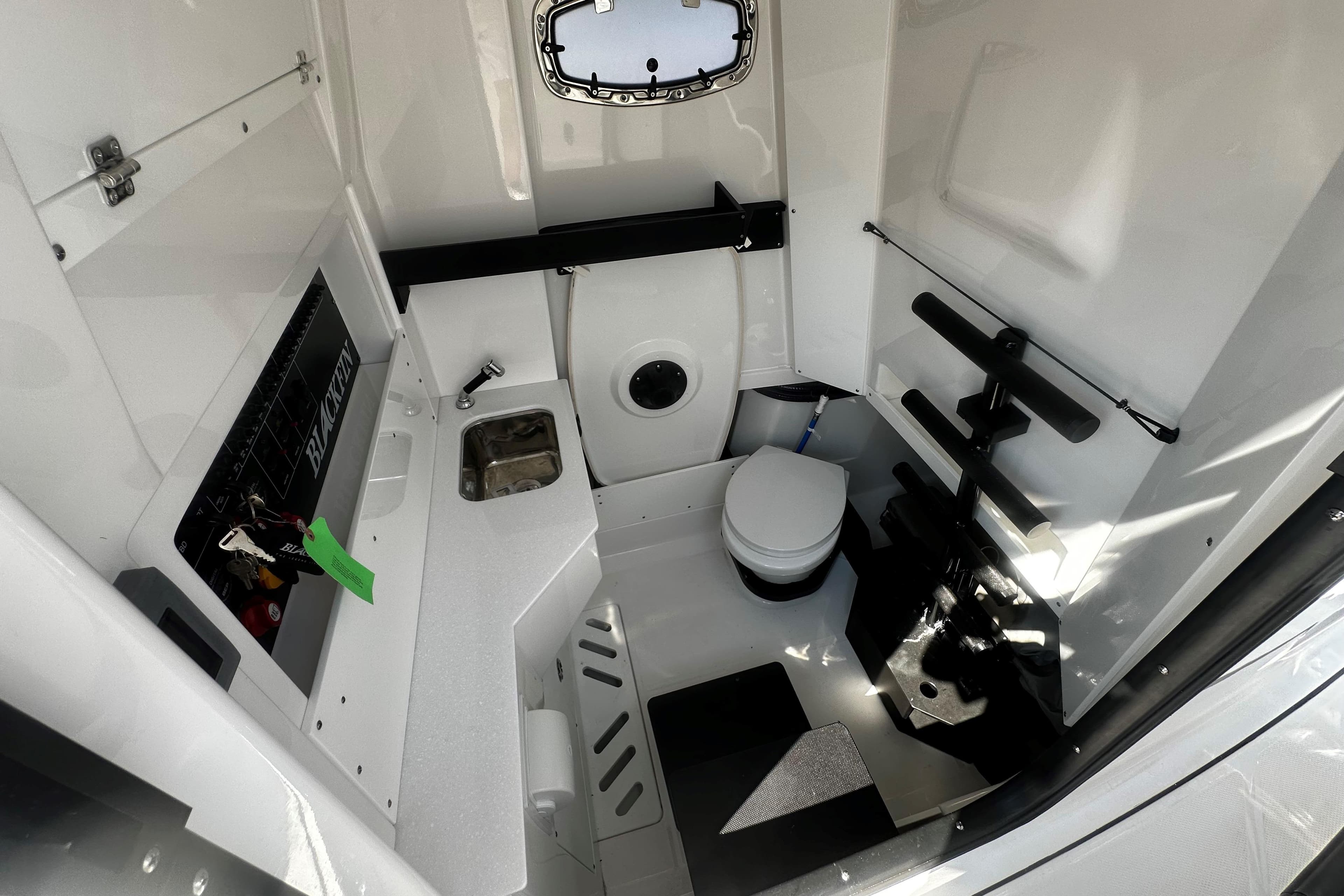 2025 Blackfin 332 CC boat interior with sink, toilet, and storage area.